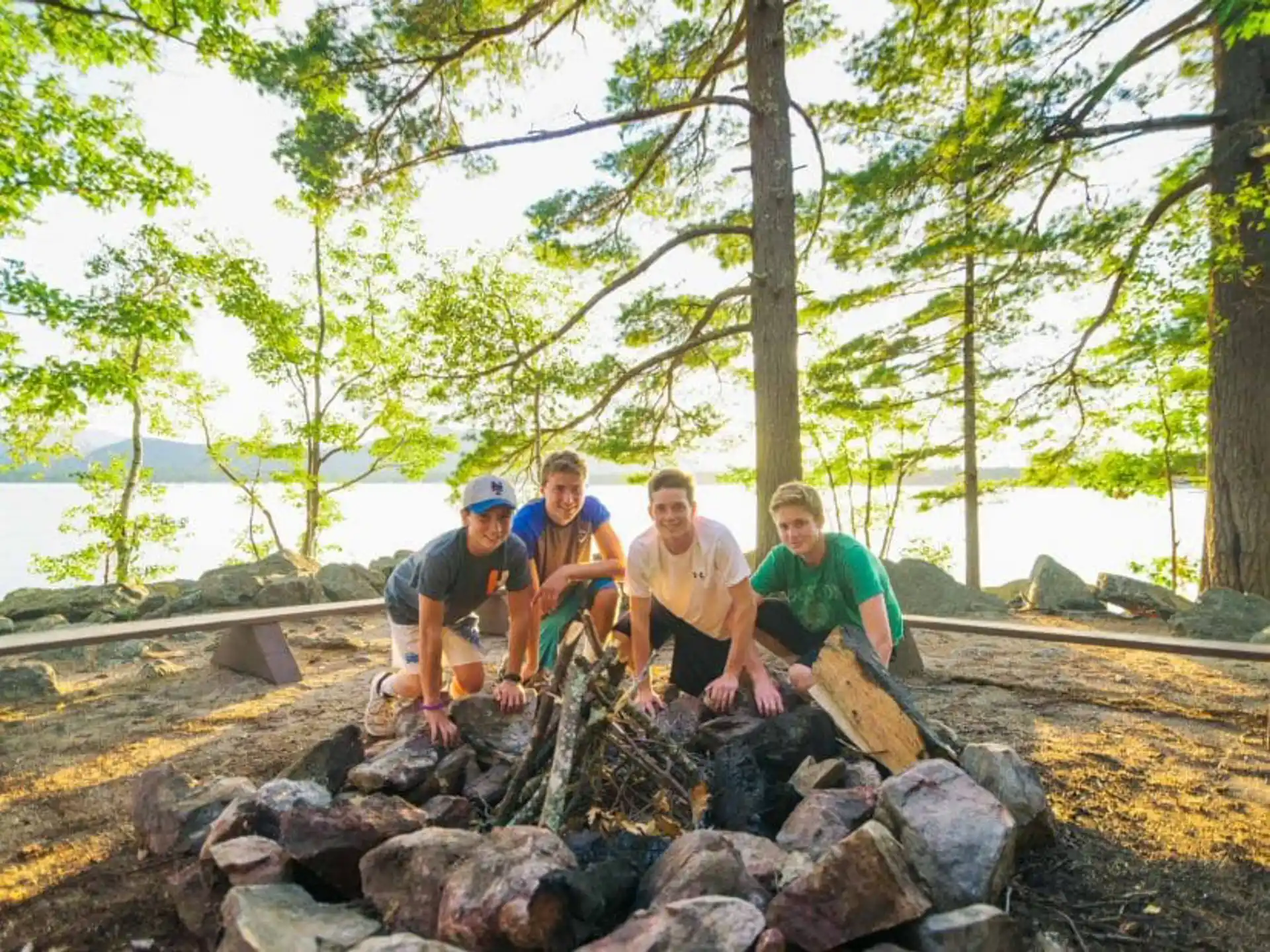 a group of people sitting on rocks by the water