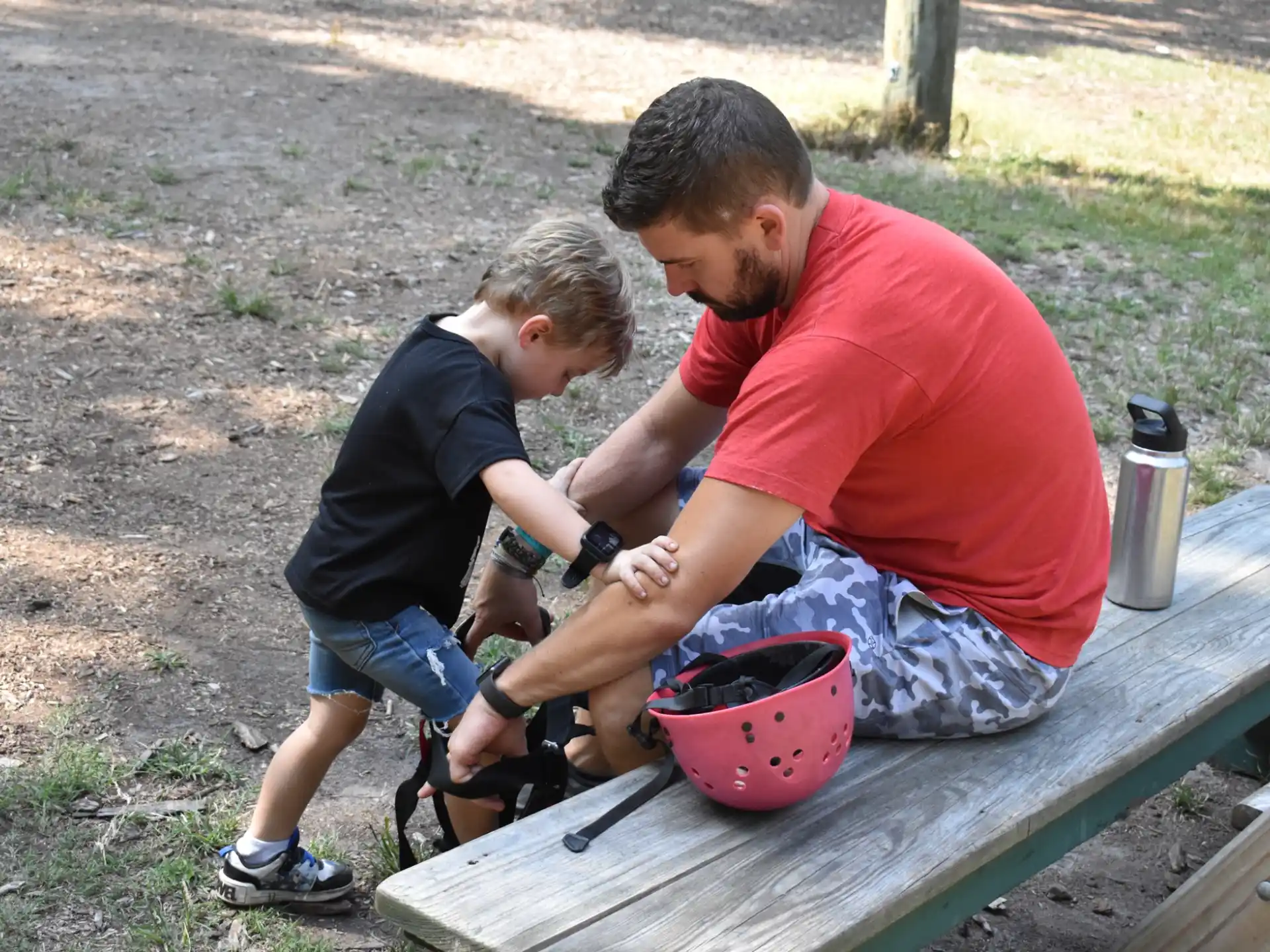 a person and a boy sitting on a picnic table