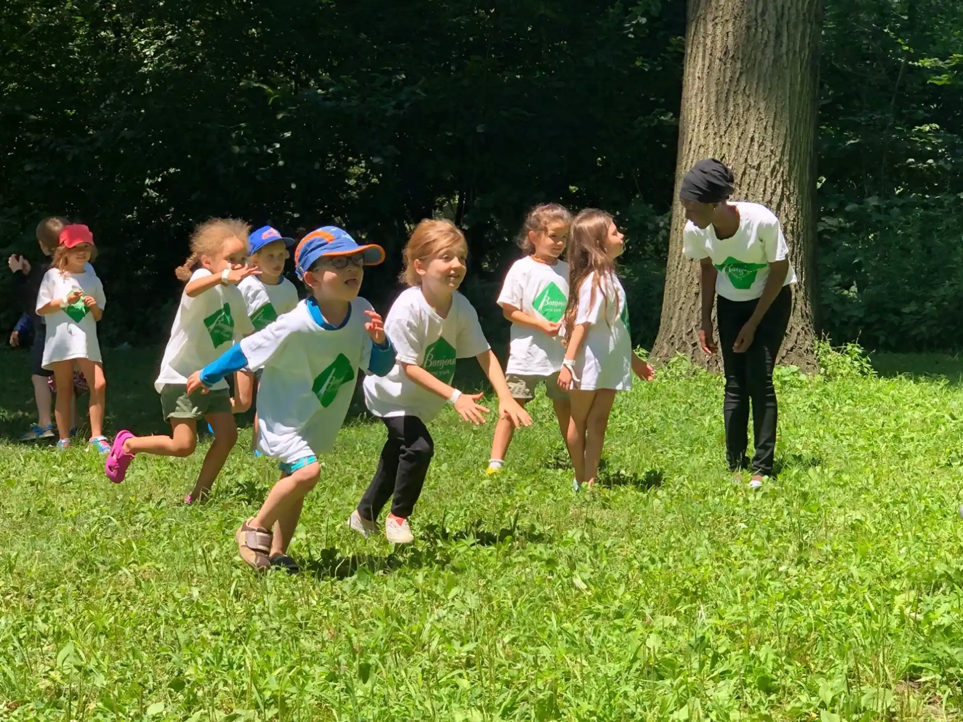 a group of children running in a grassy area