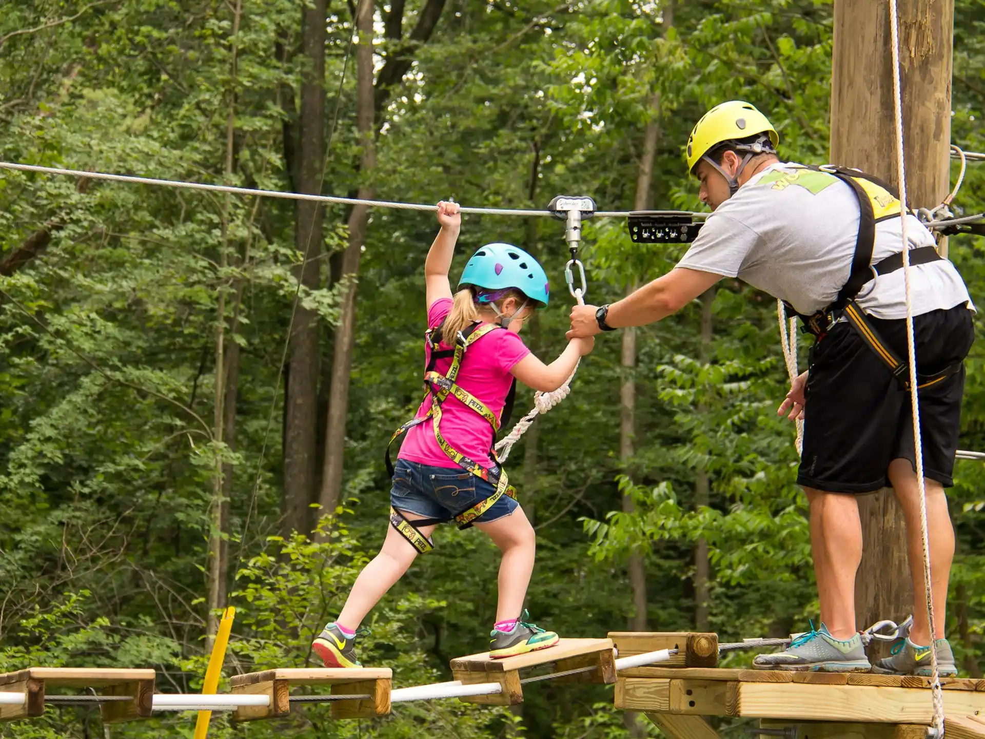 a man and a girl on a wooden platform with trees in the background