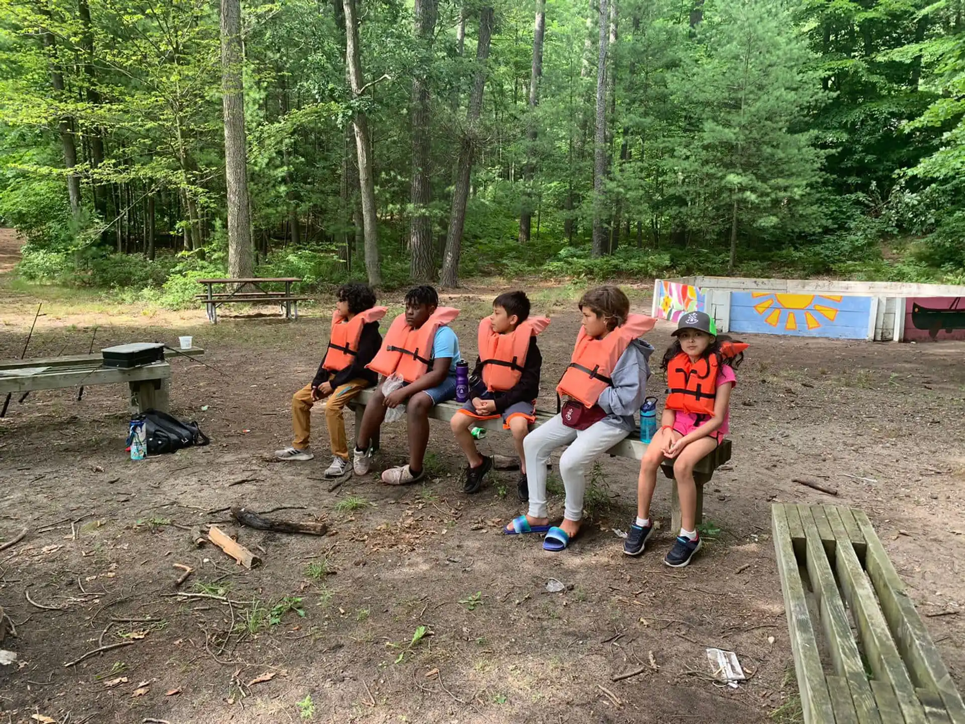 a group of people sitting on a bench in the woods