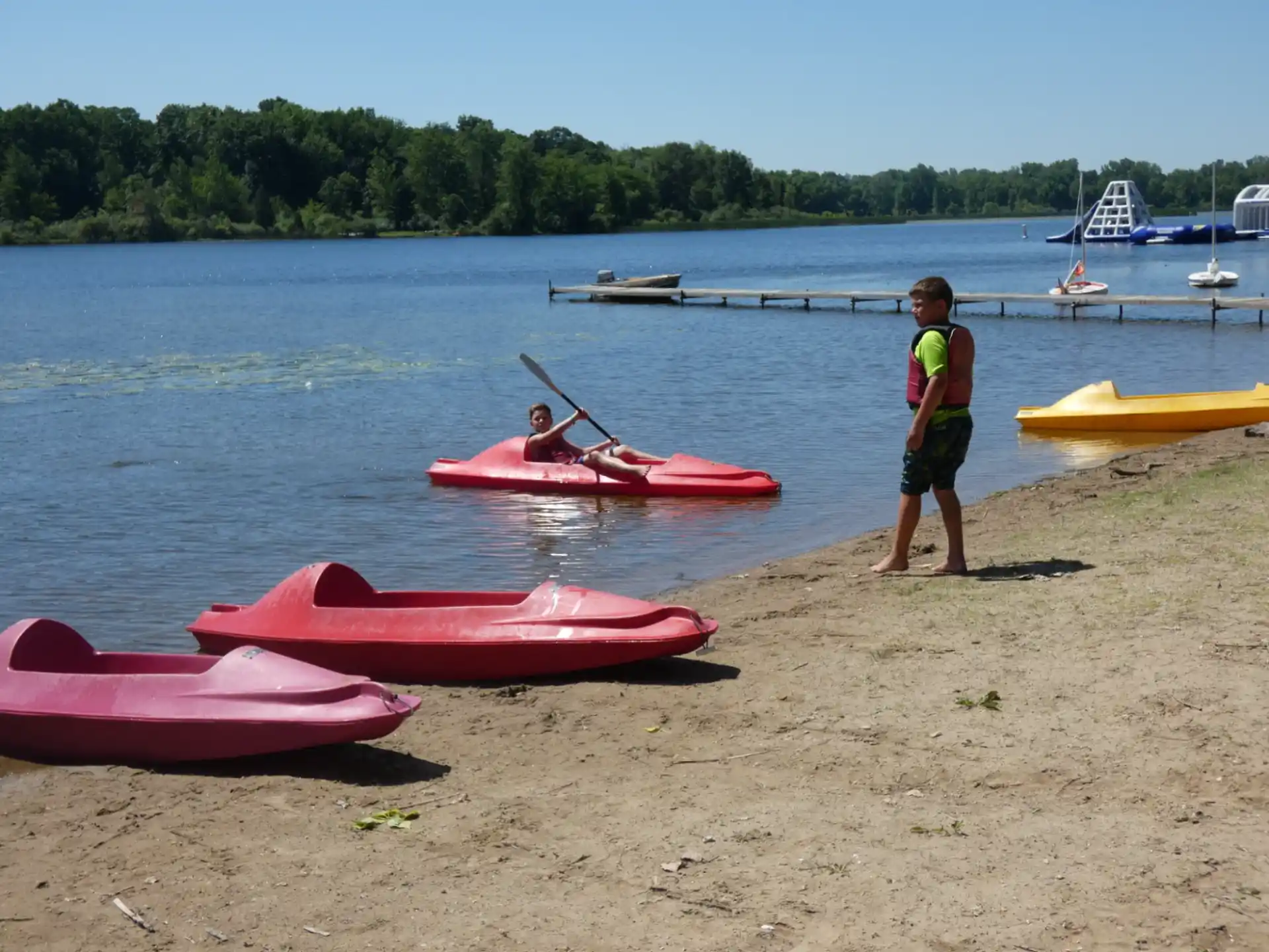 a man and a woman with kayaks on a beach