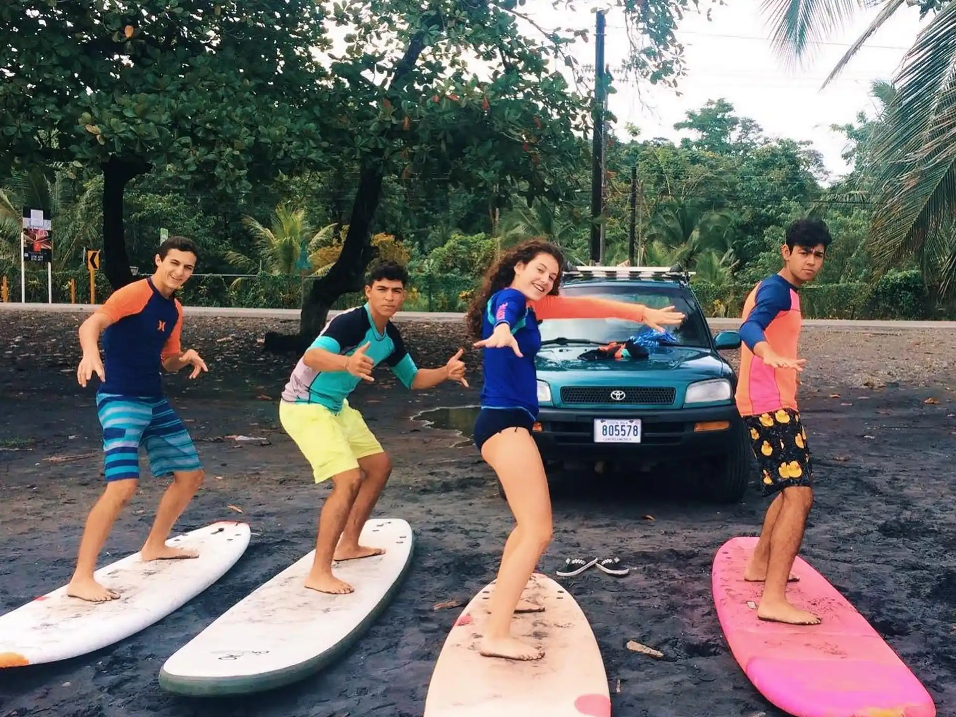 a group of people stand on surfboards