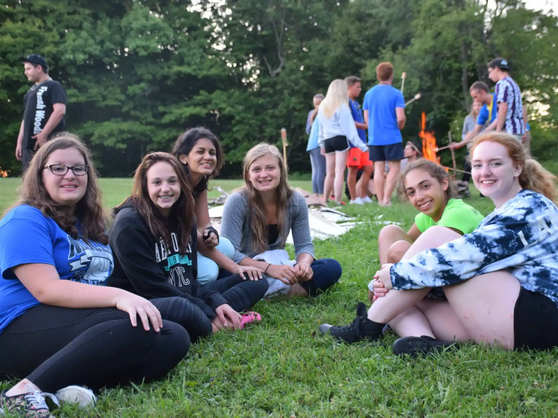 a group of people sitting on the grass