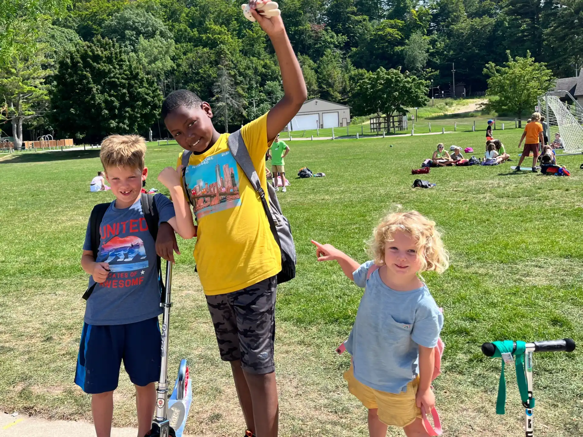 a group of kids standing on a sidewalk with their arms raised
