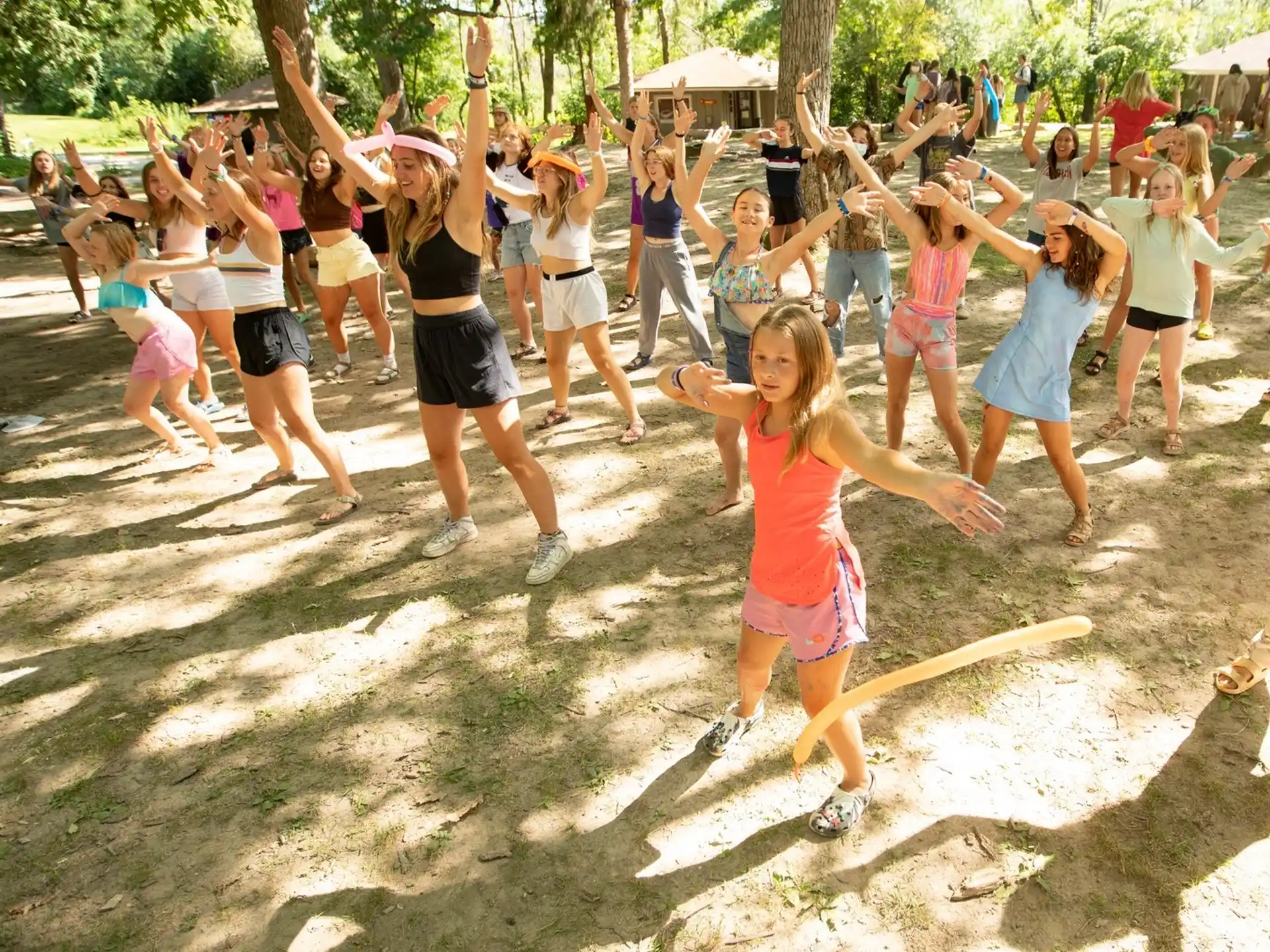 a group of people dancing in a sandy area