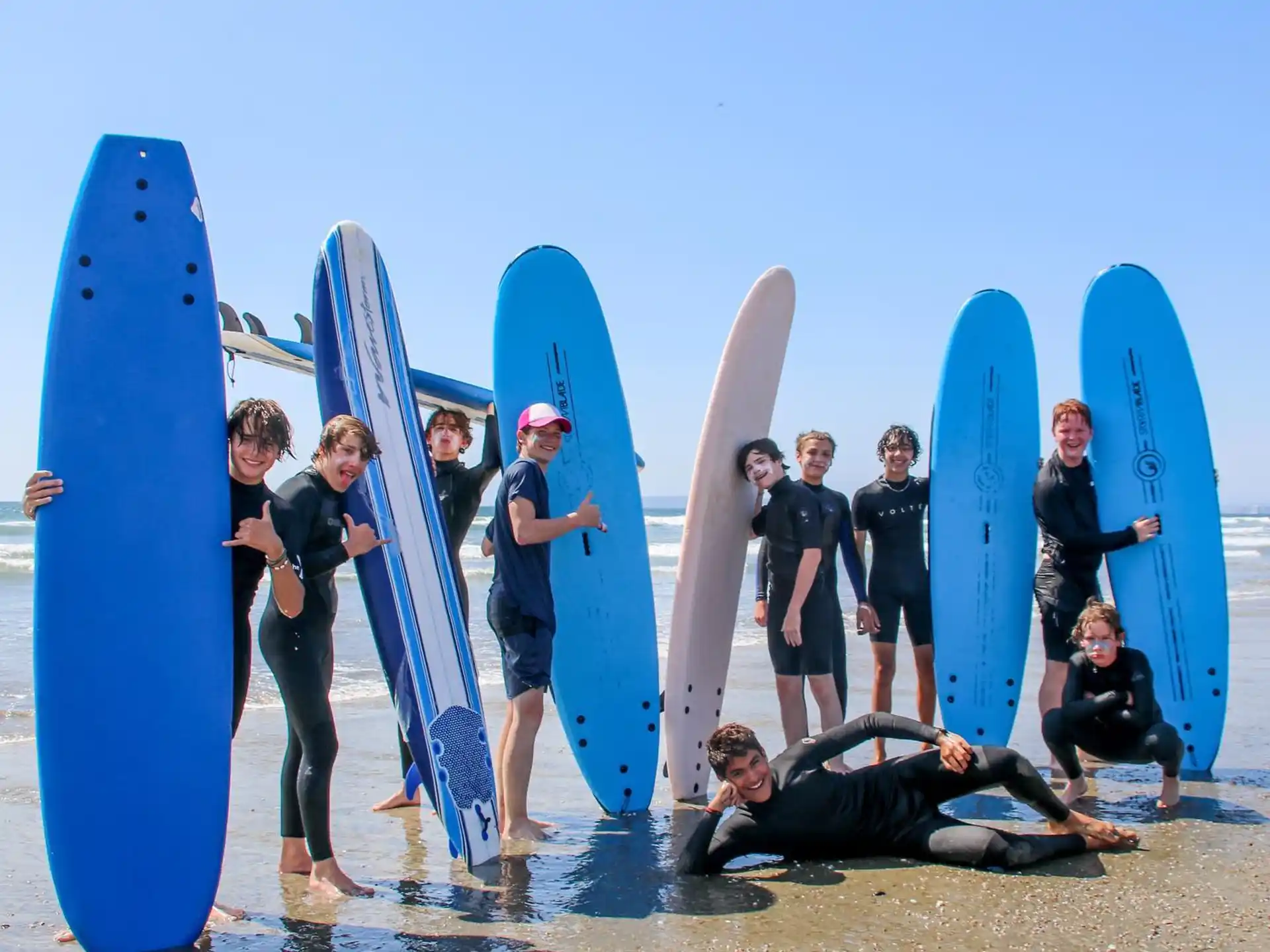 a group of surfers pose for a photo