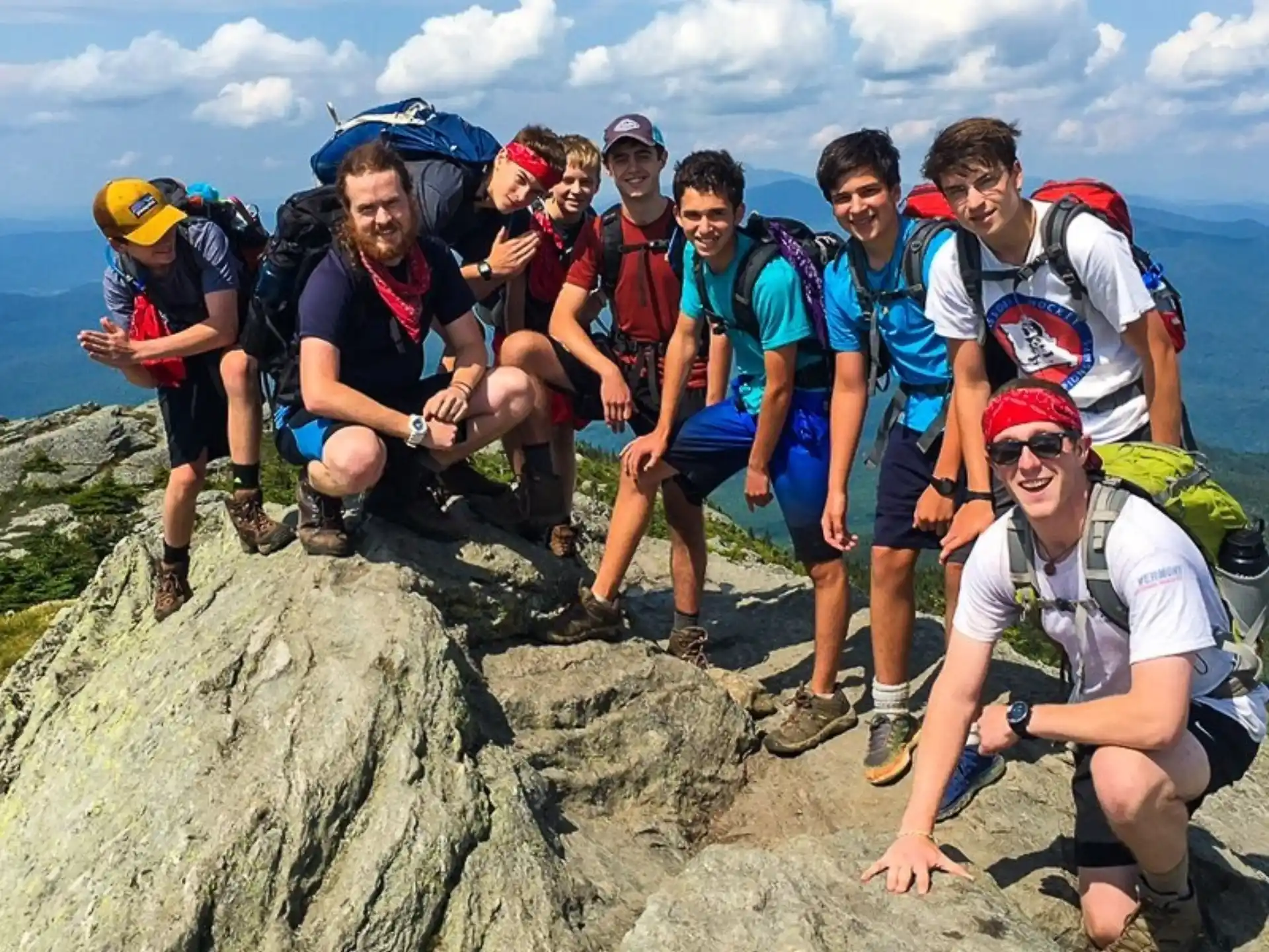 a group of people posing on a mountain
