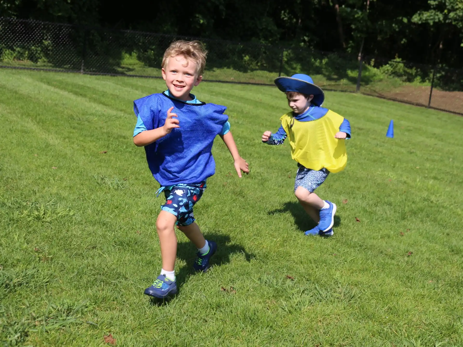 two boys running on grass