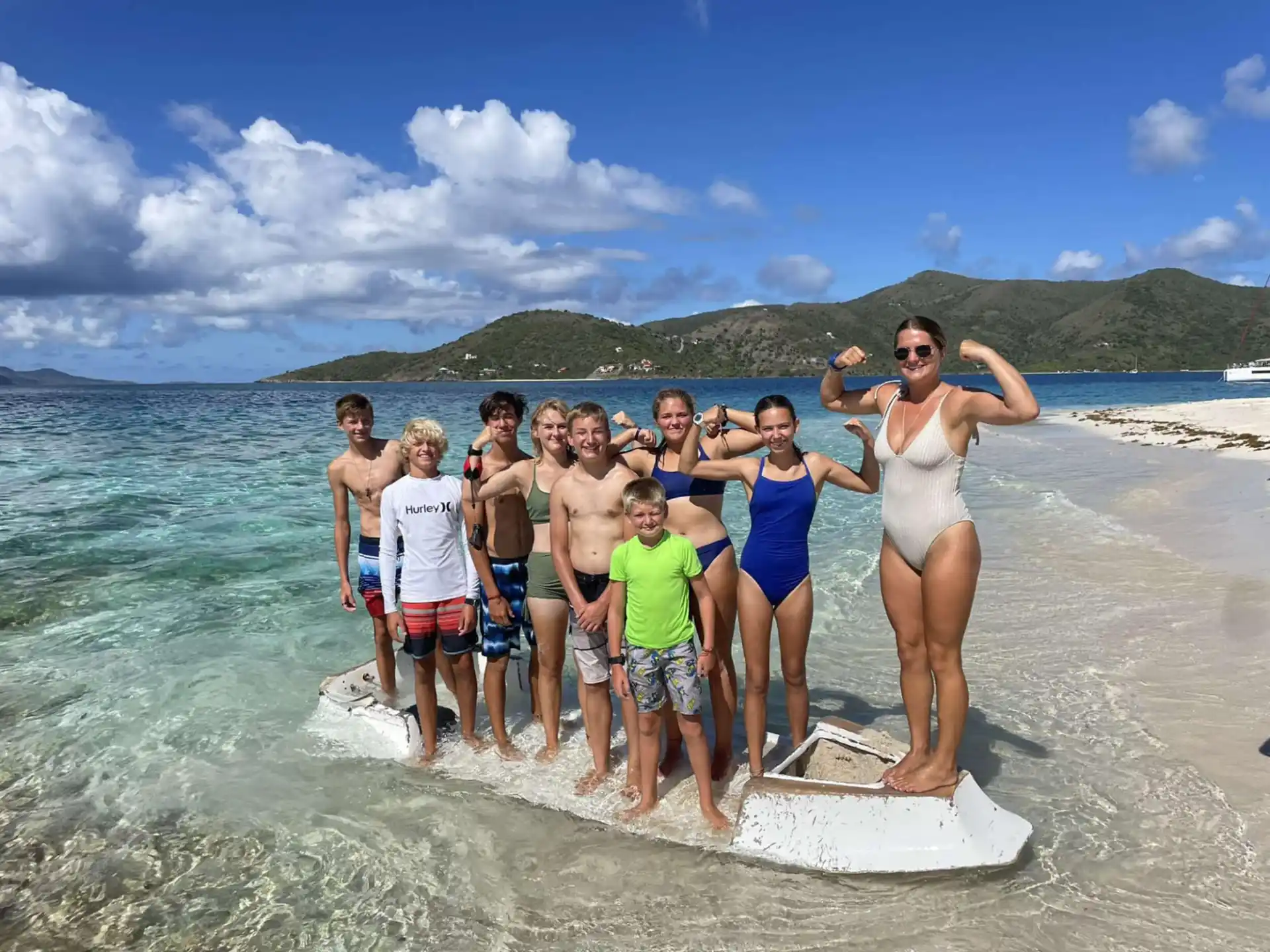 a group of people standing on a surfboard in the water