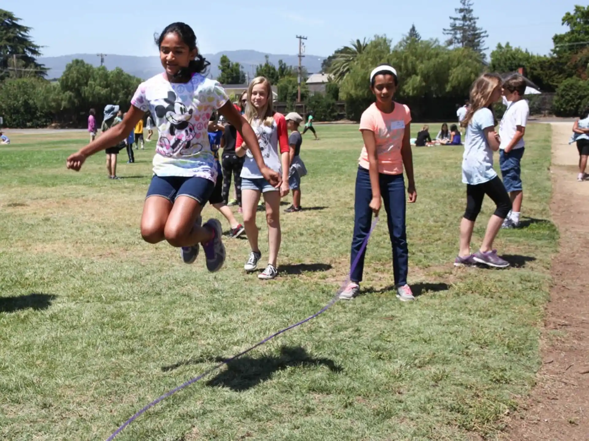 a group of people running on a grass field