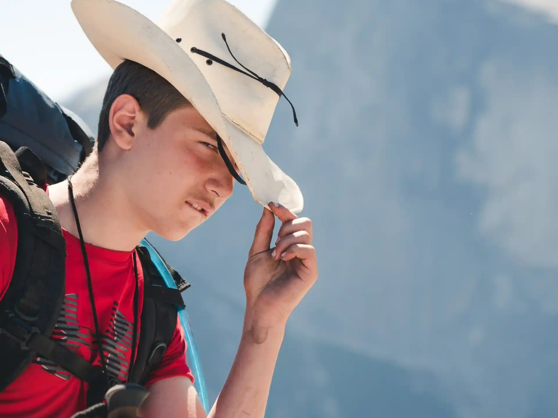 a person wearing a hat and smoking a cigarette