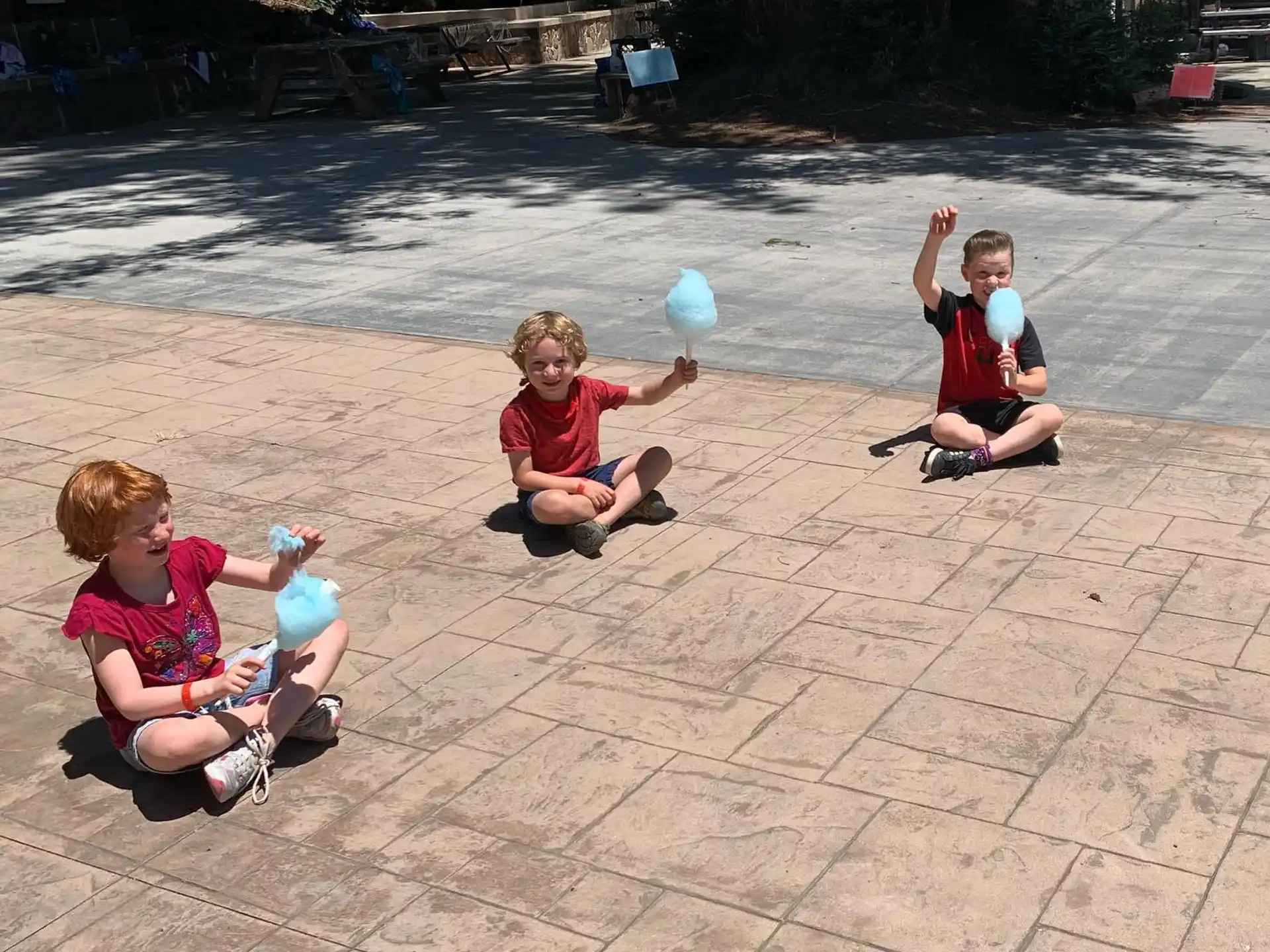 a group of kids playing with a ball on a brick surface