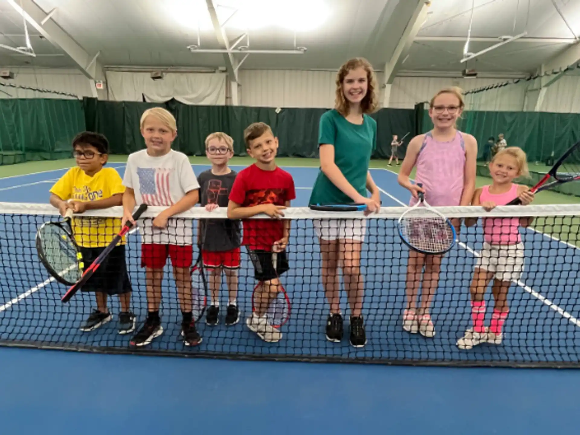 a group of kids holding tennis rackets