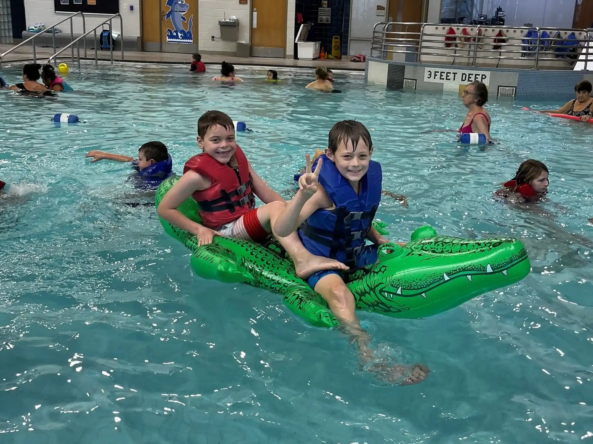 a couple of kids on a floaty in a pool