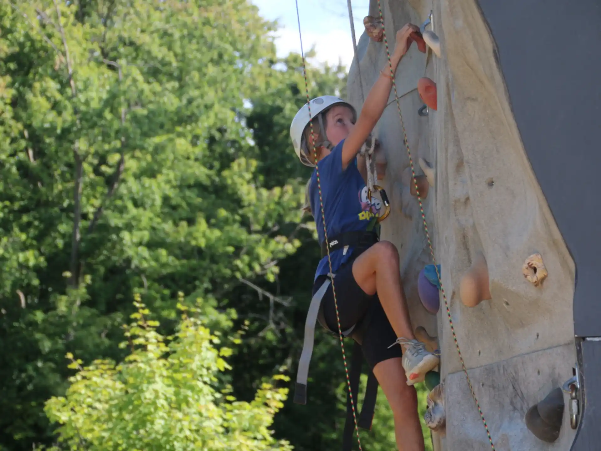 a young boy climbing a rock wall