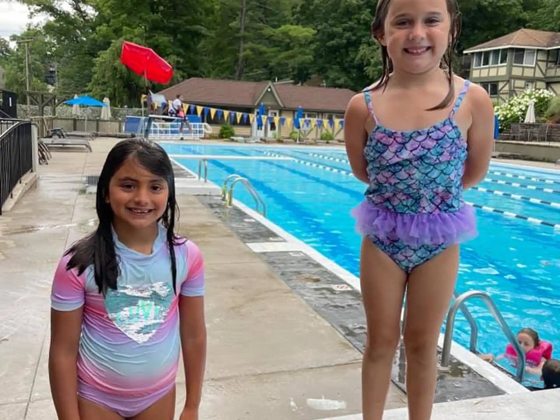 two girls in swimsuits by a pool