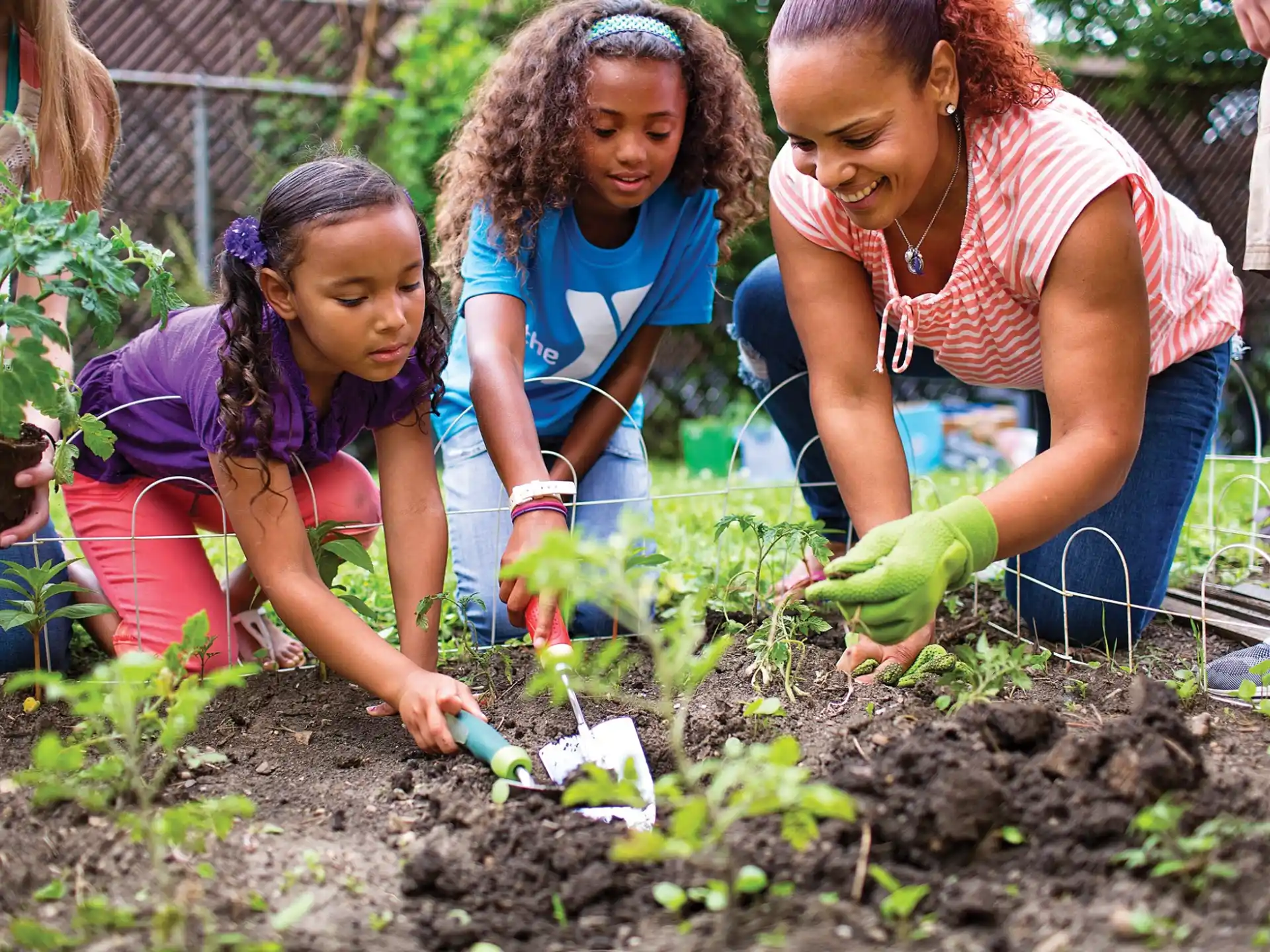 a group of young girls planting plants