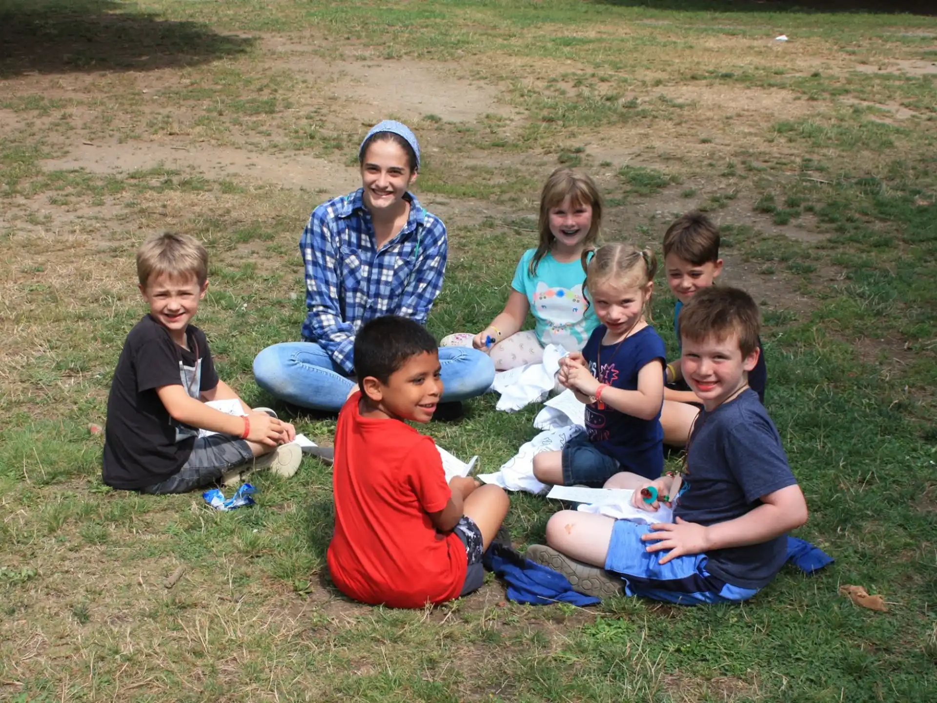 a group of children sitting on the grass