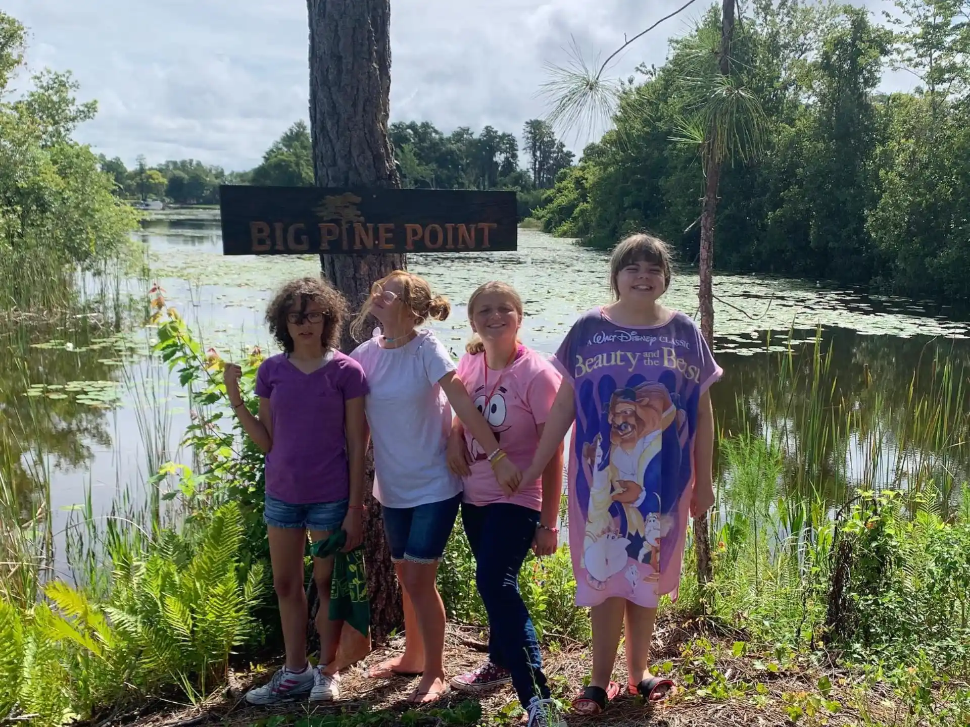 a group of girls posing for a picture next to a river