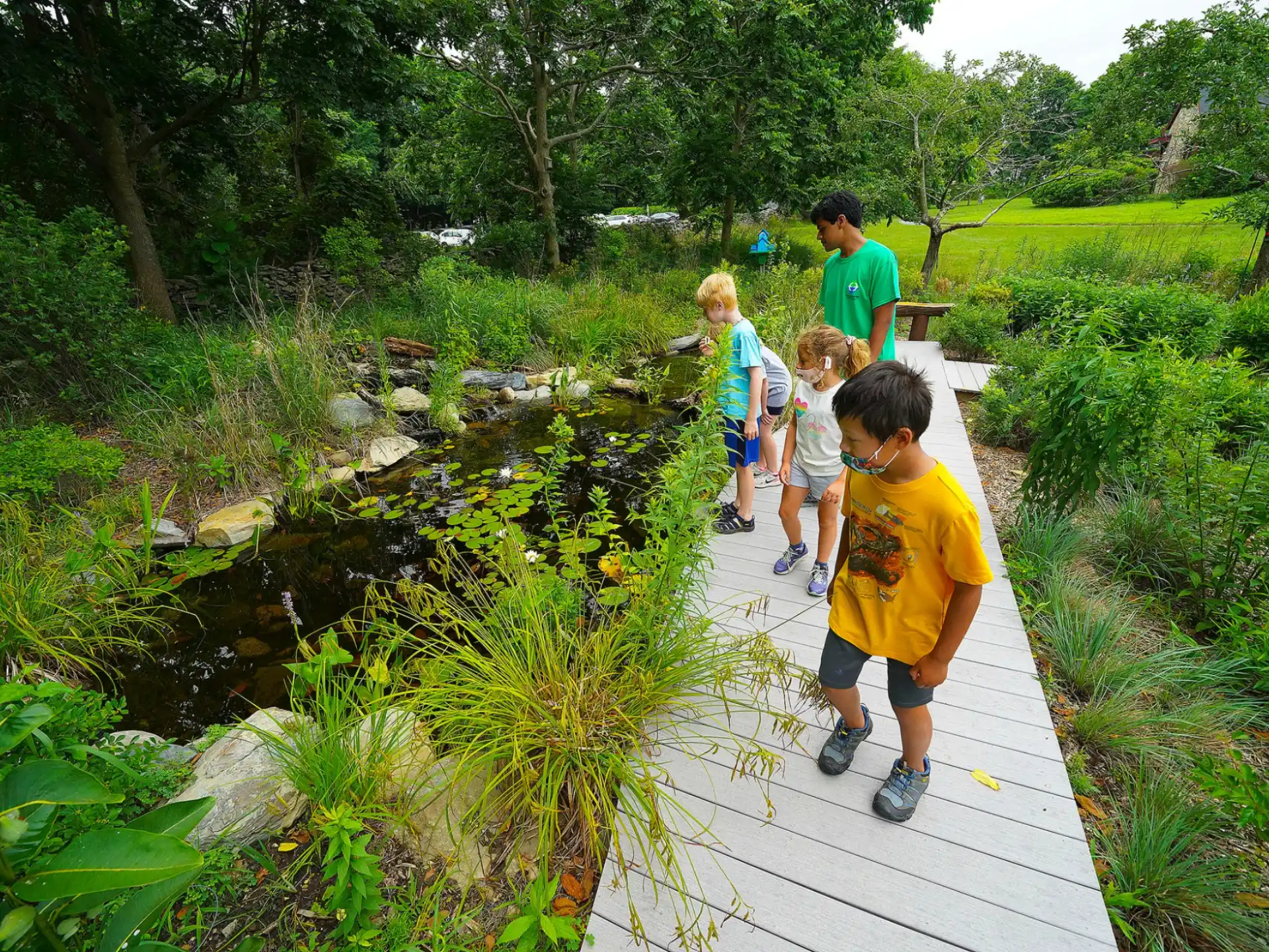 a group of people walking on a path in a garden
