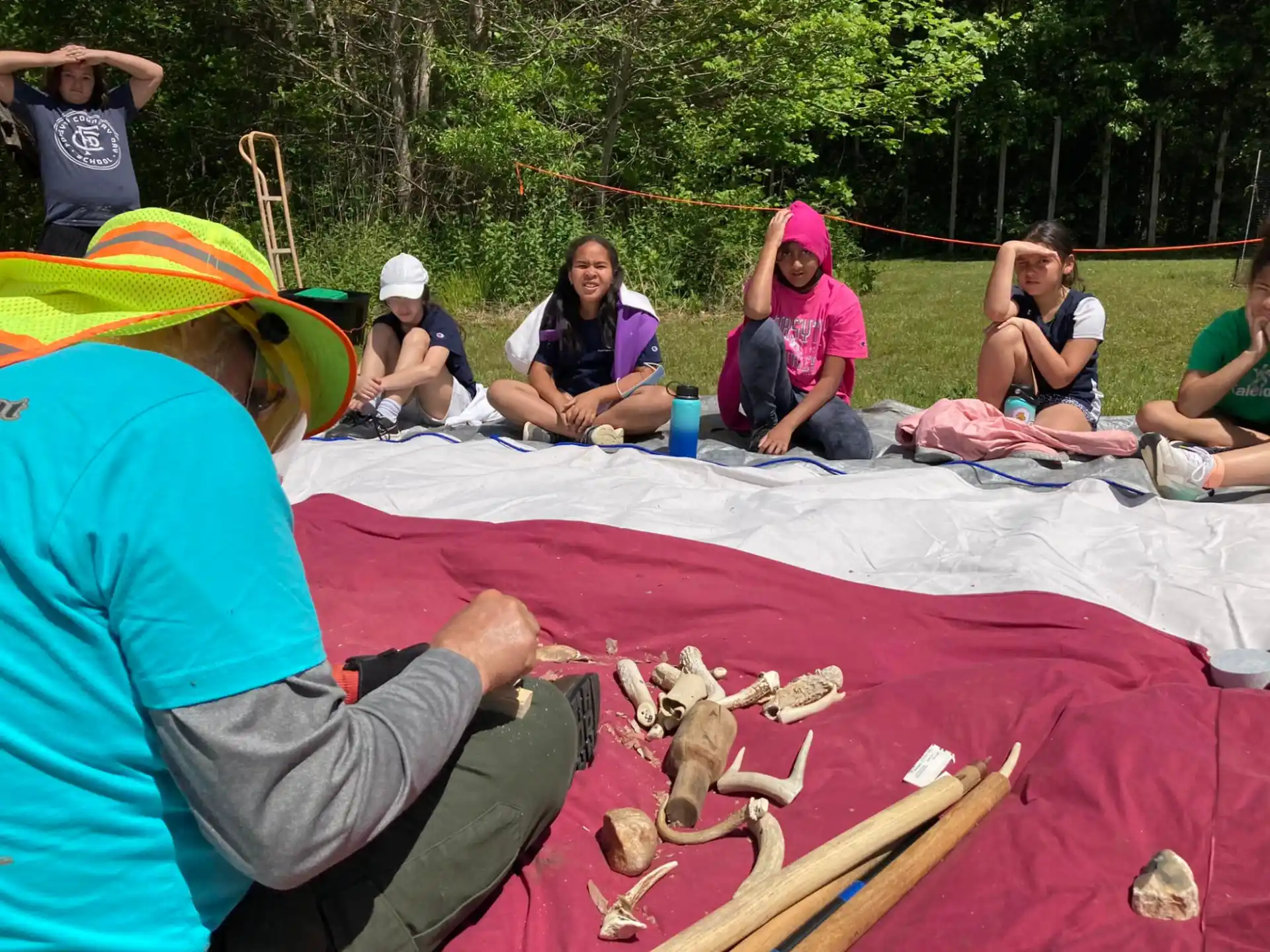 a group of people sitting on a blanket outside