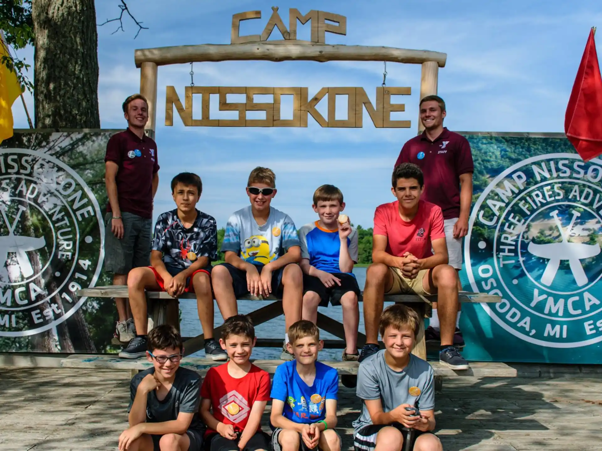 a group of people sitting on a bench in front of a sign