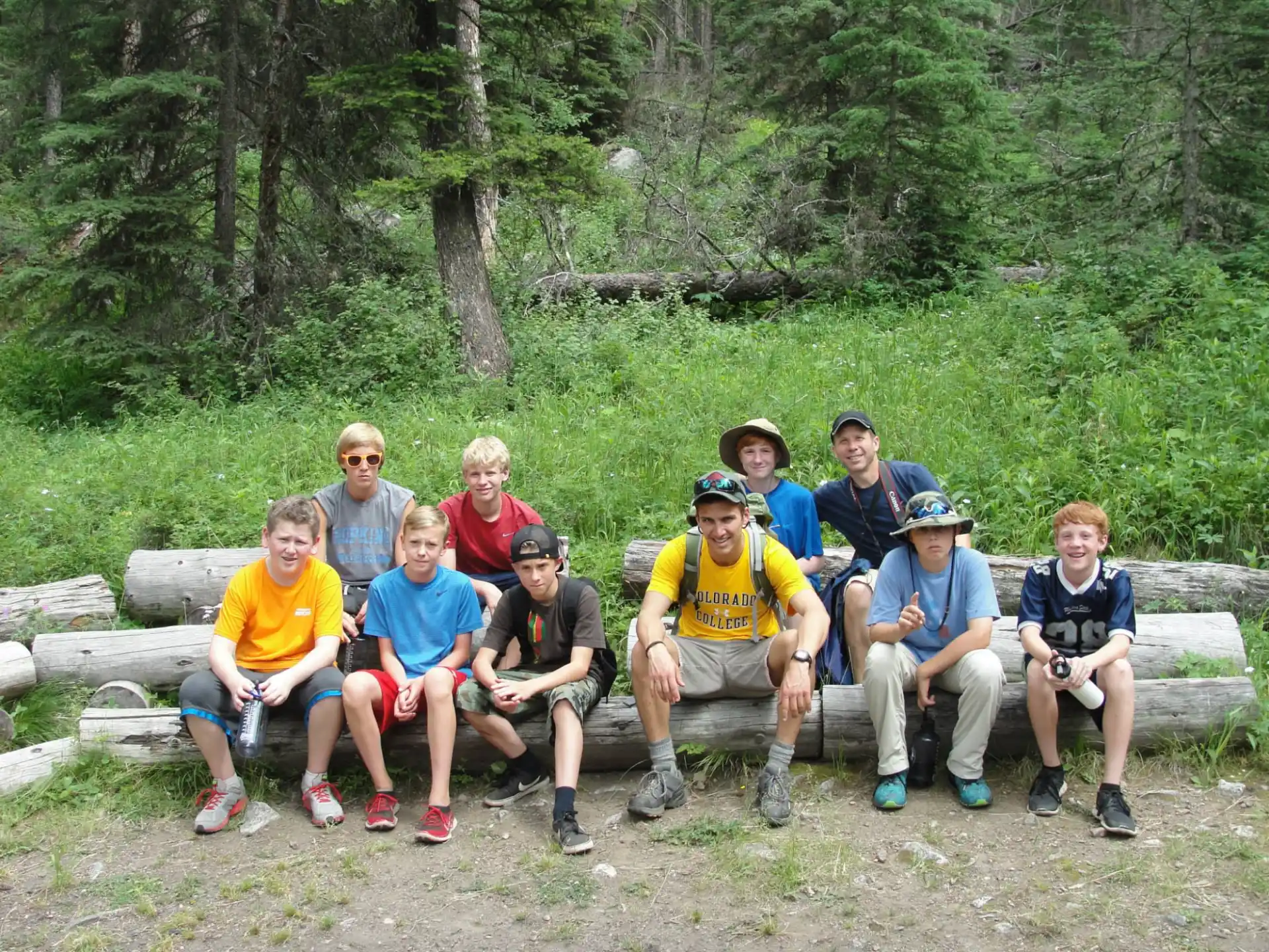 a group of people sitting on a bench in the woods