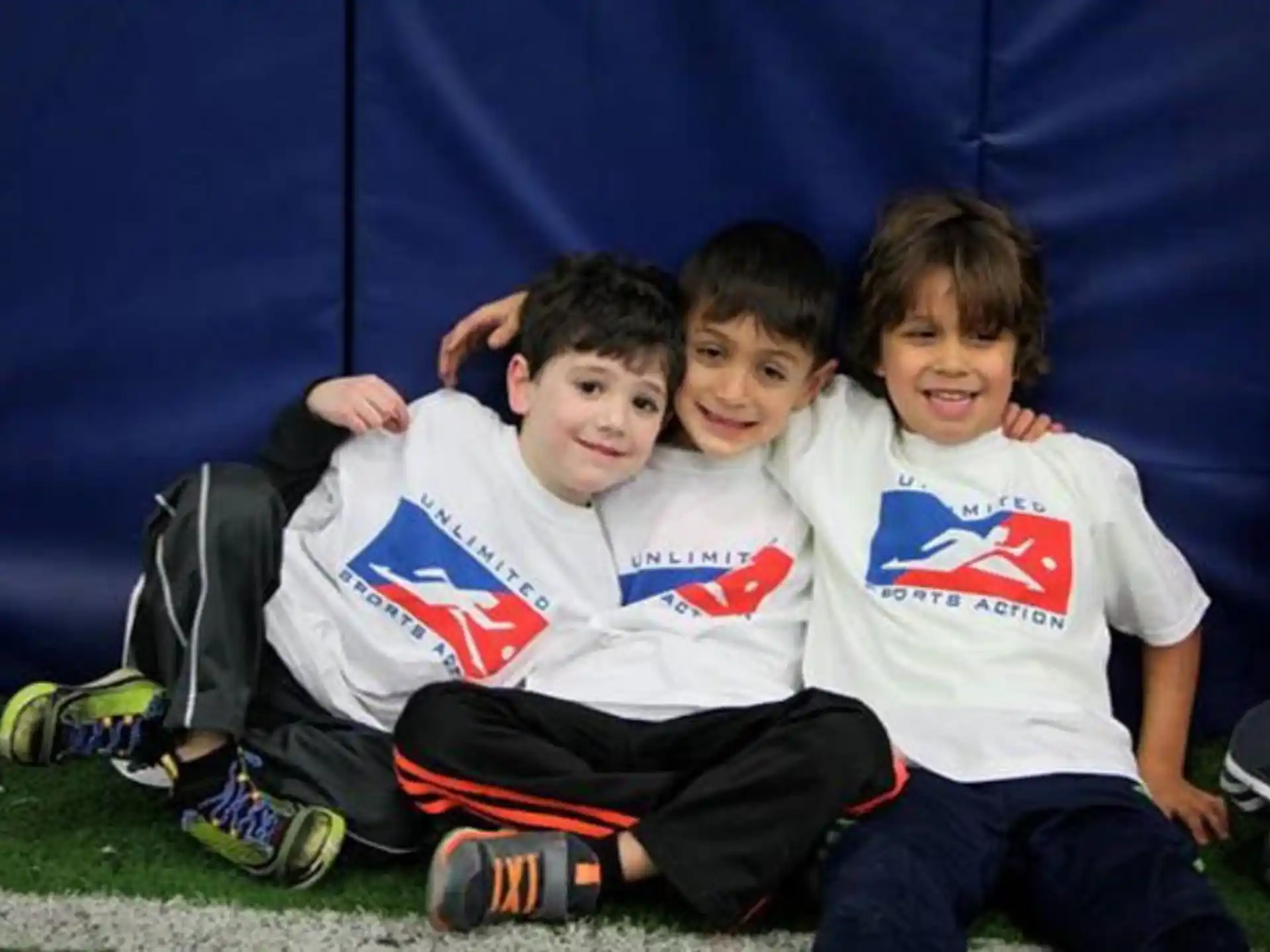 a group of boys sitting on the ground posing for the camera