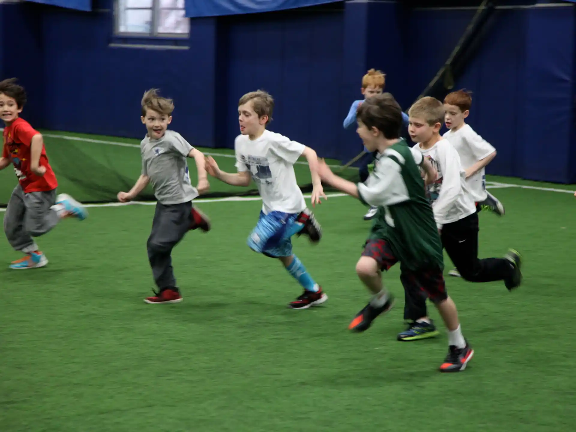 a group of kids running on a field