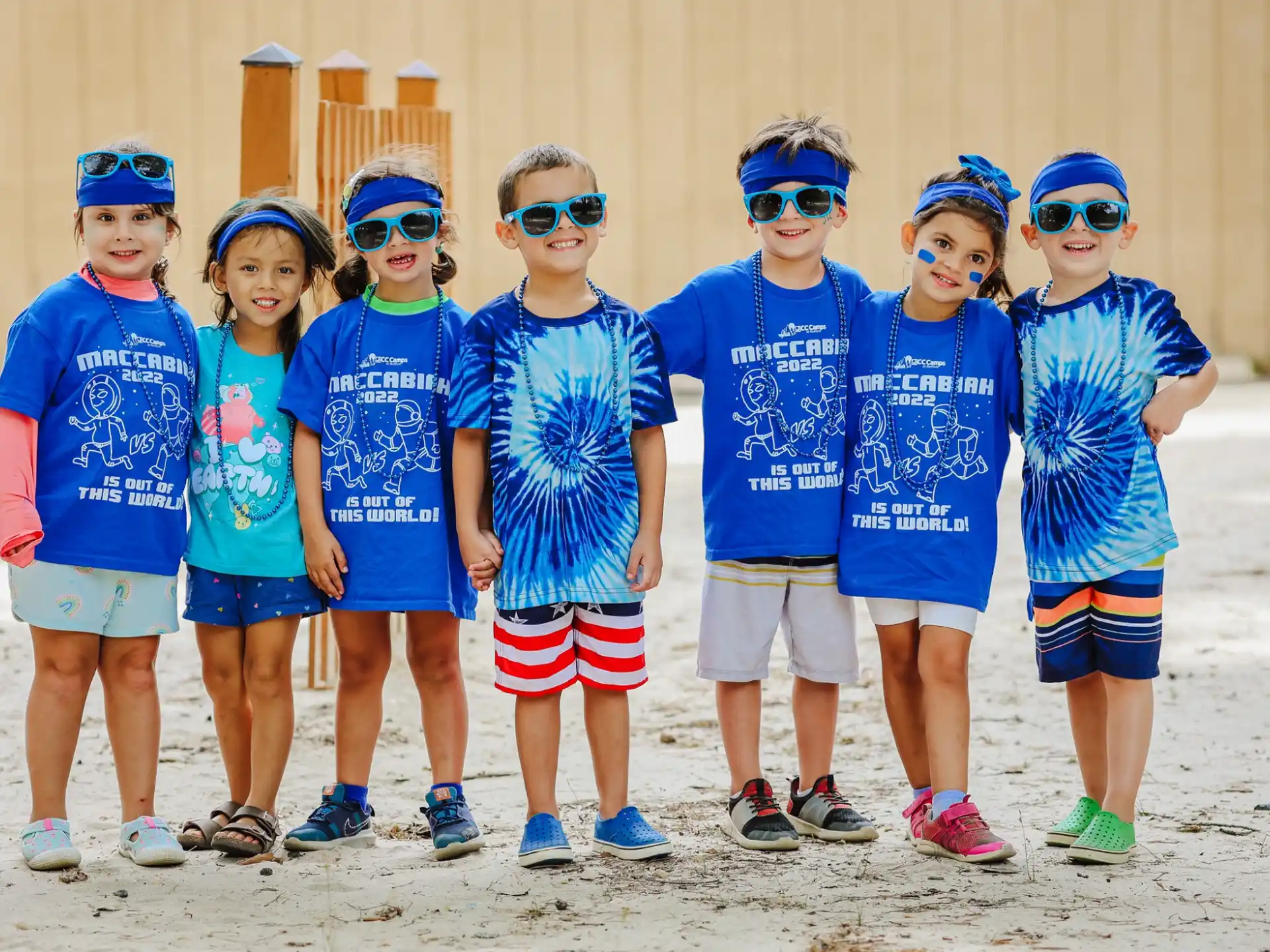 a group of children wearing blue and white shirts and blue bandanas