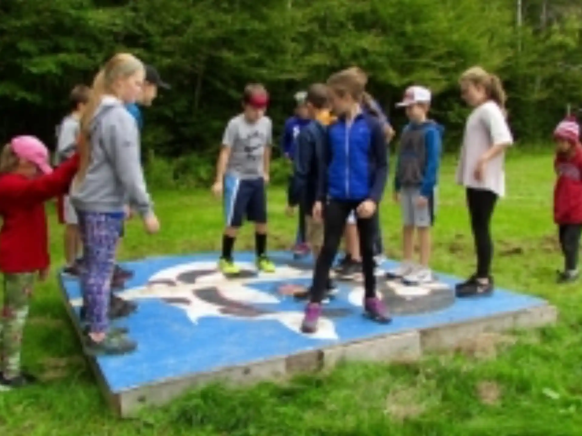 a group of children standing around a pool