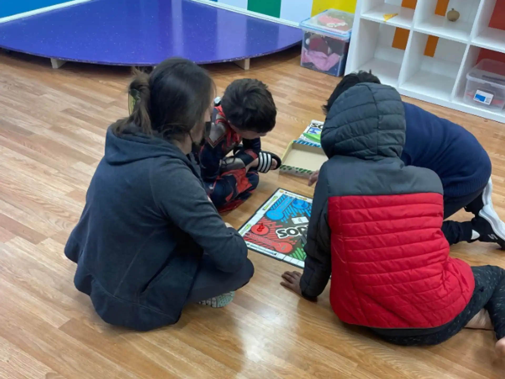 a group of people sitting on the floor playing a board game