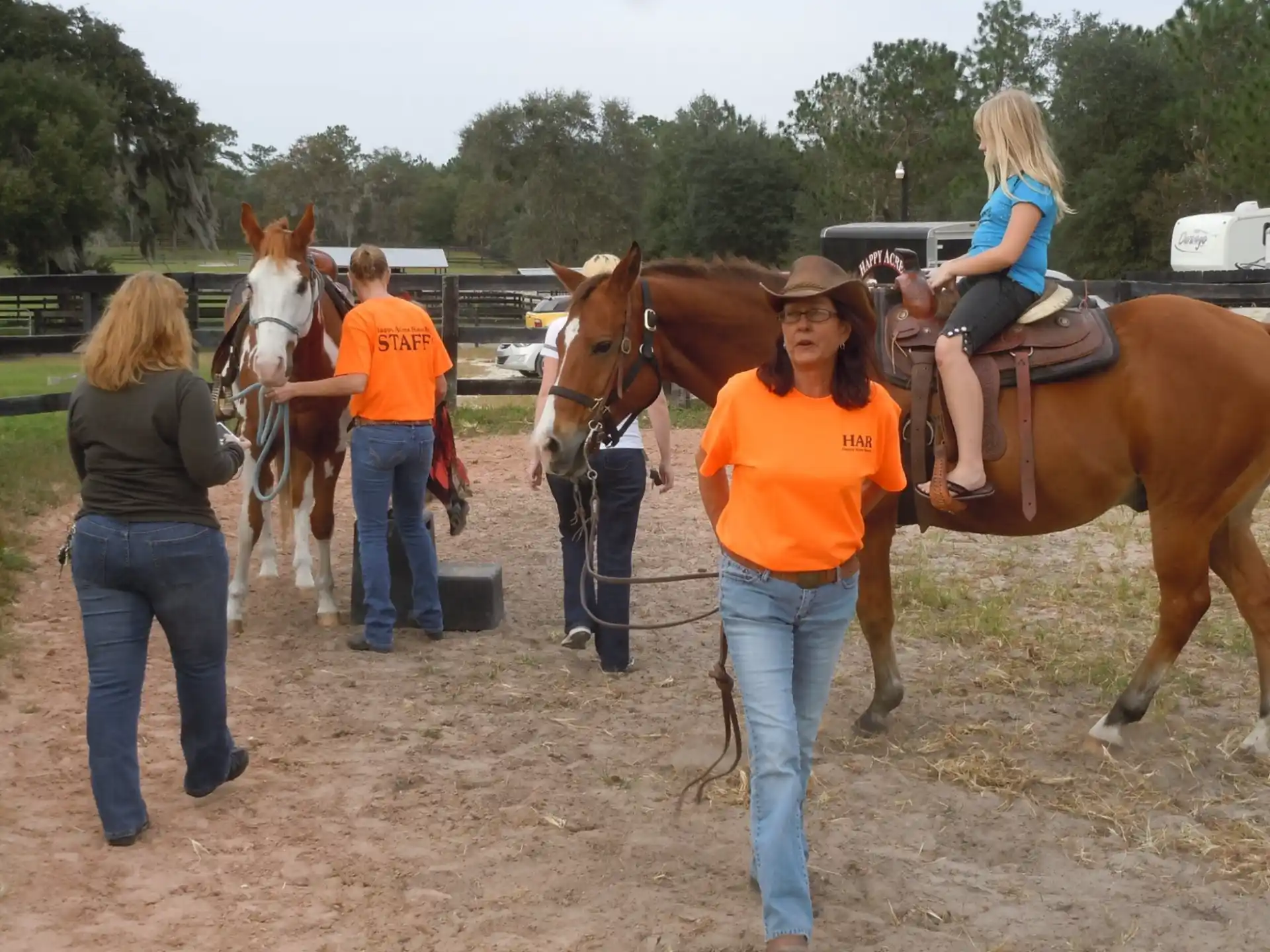 a group of people stand around some horses
