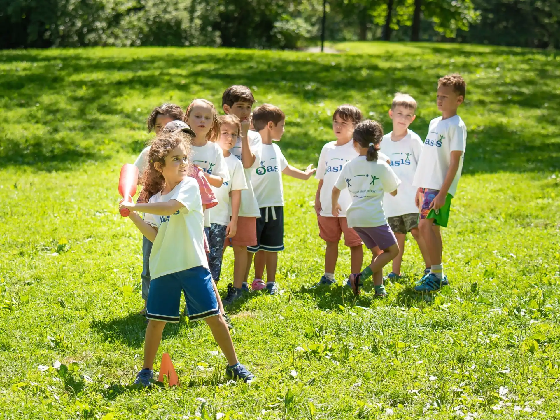 a group of children running on a grass field