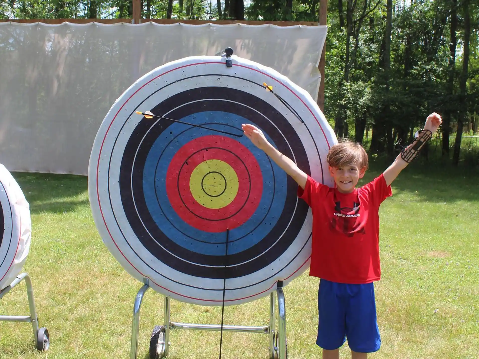 a boy holding a large blue and red shield