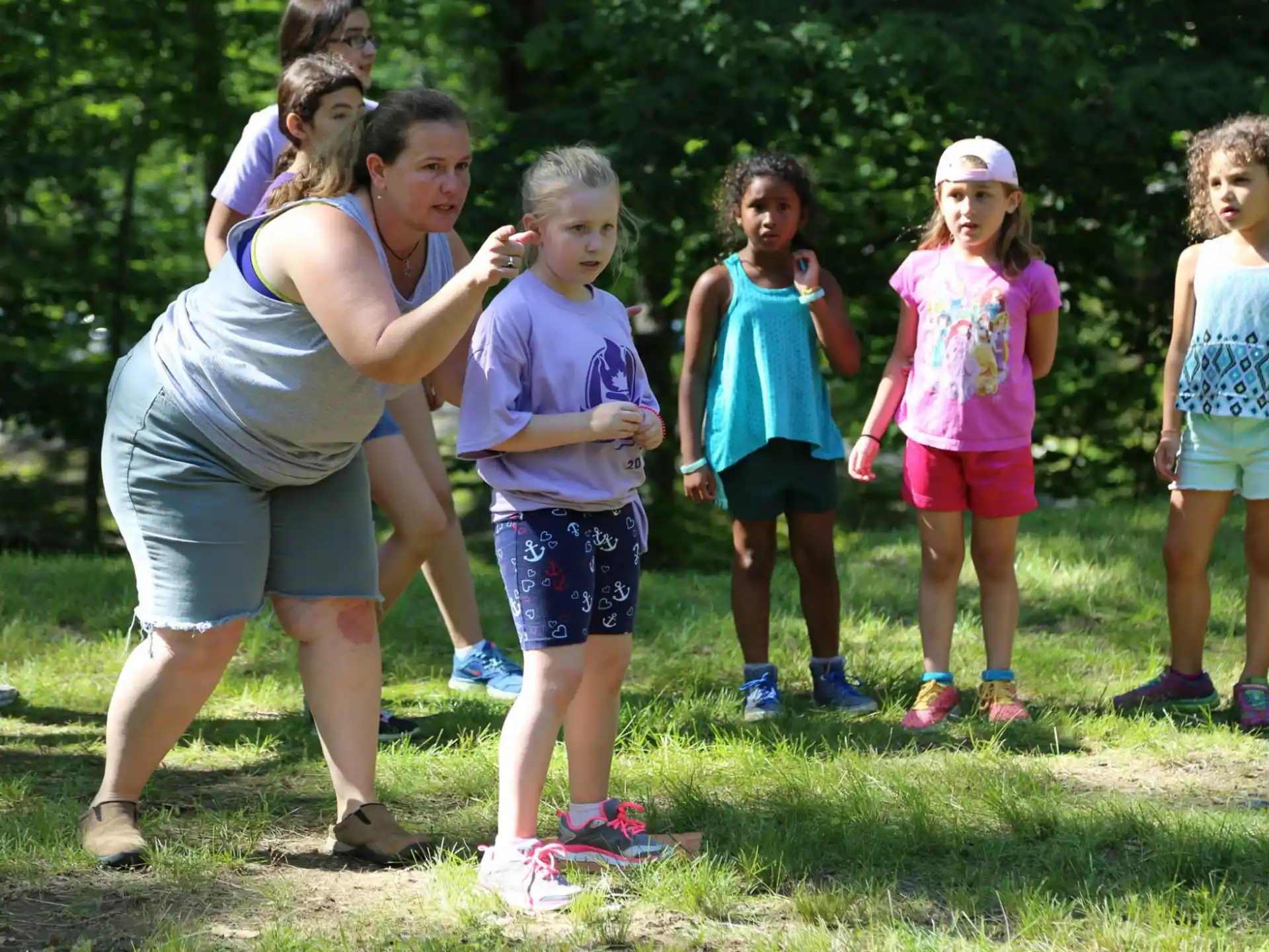 a group of children standing on grass
