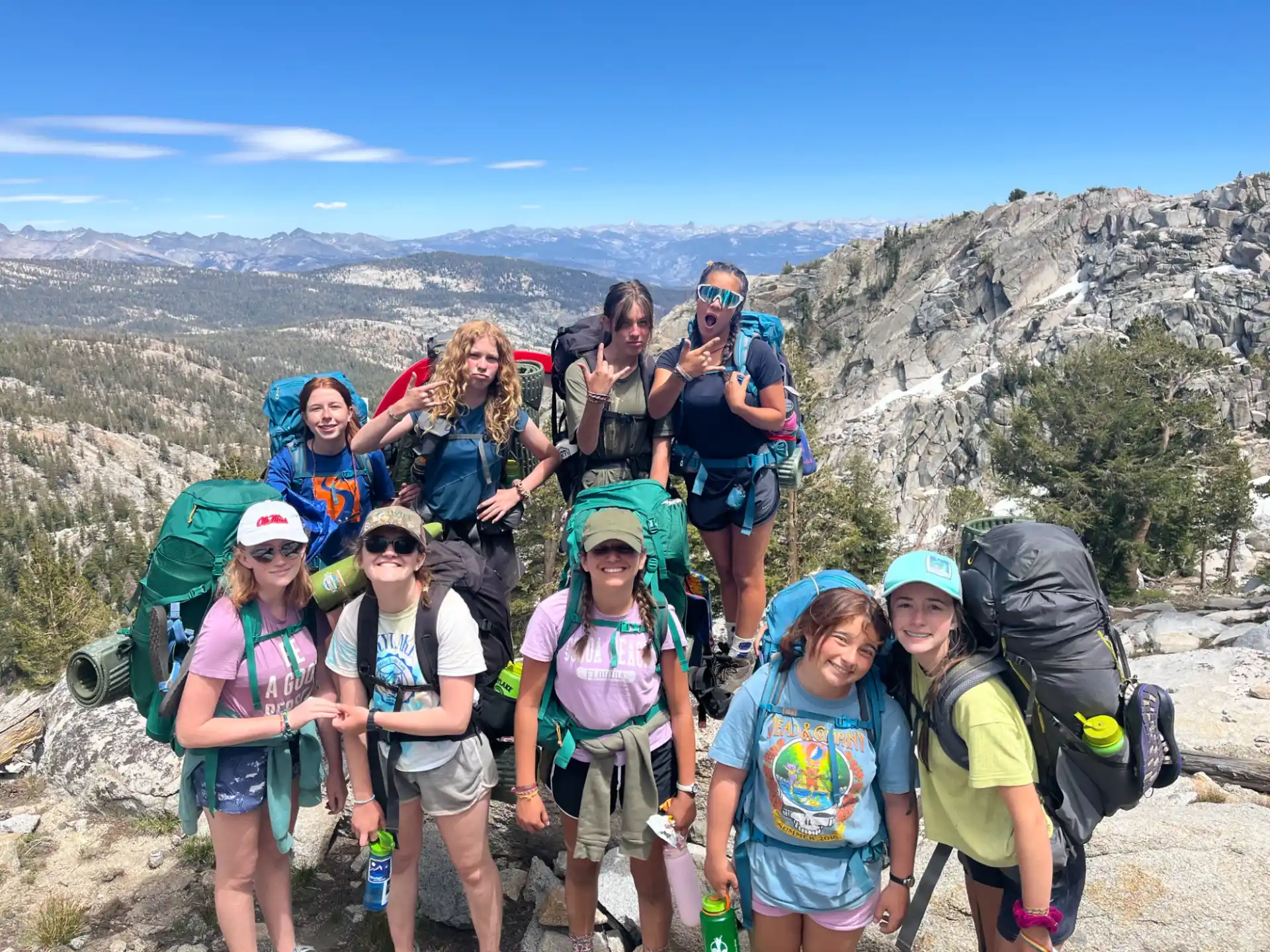 a group of people posing for a photo on a mountain