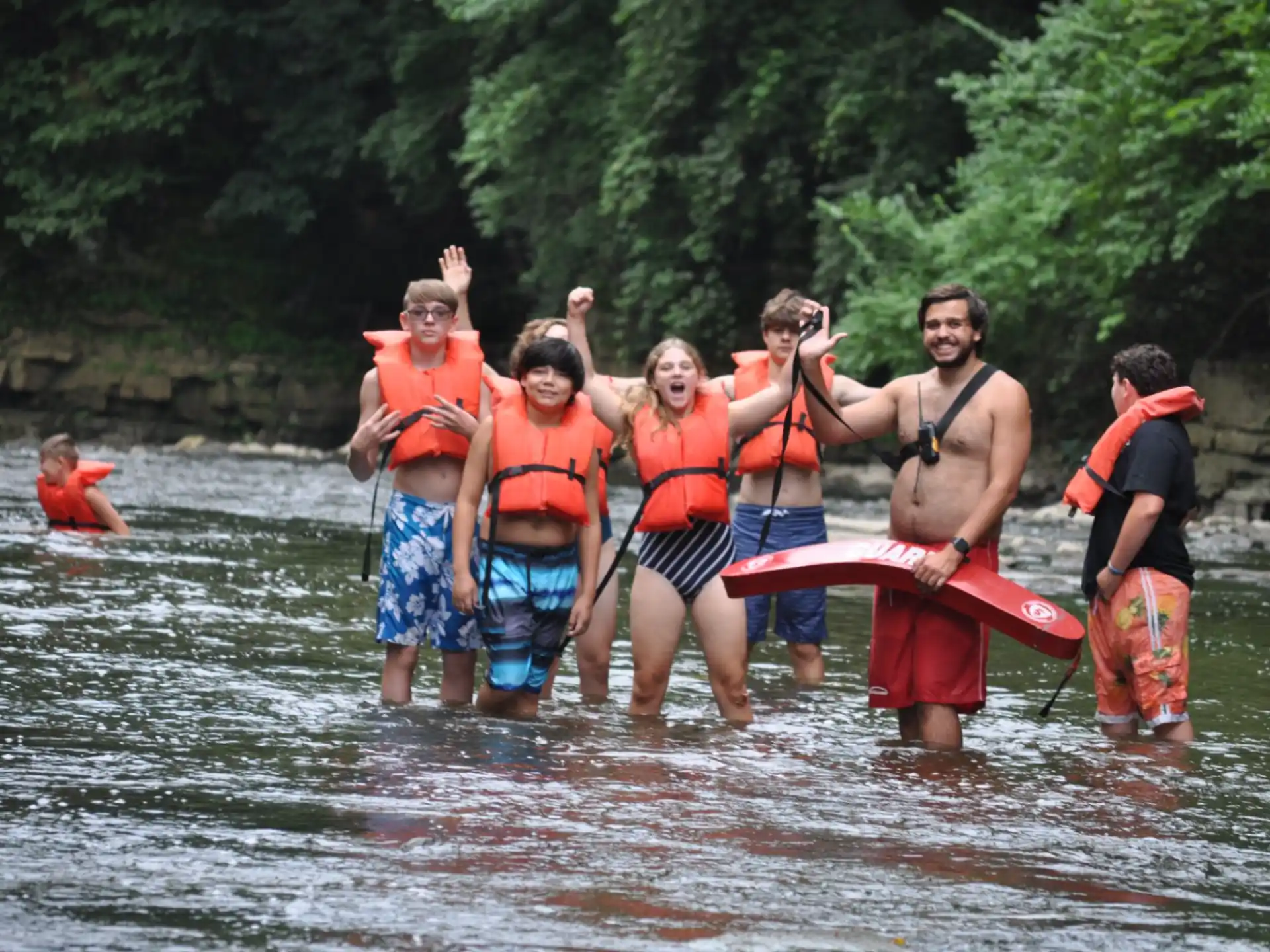 a group of people in life jackets in a river