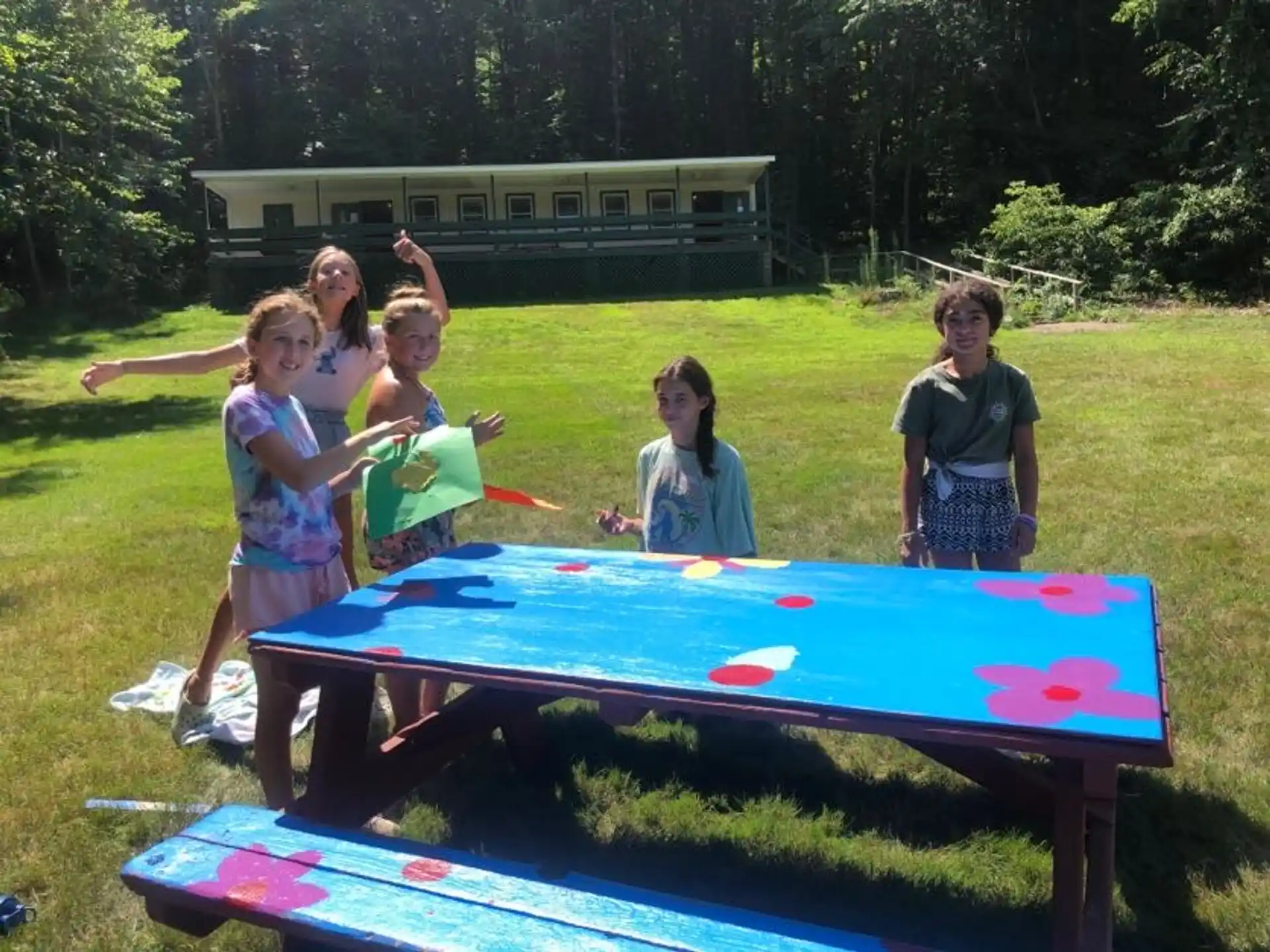 a group of children playing on a trampoline in a yard