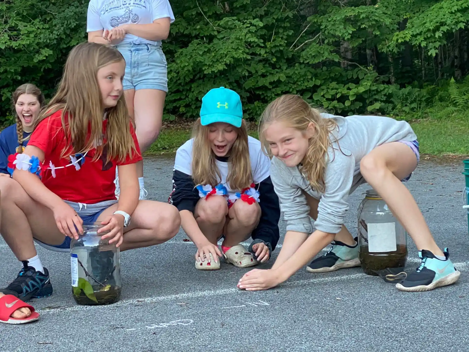 a group of girls sitting on the ground with water bottles