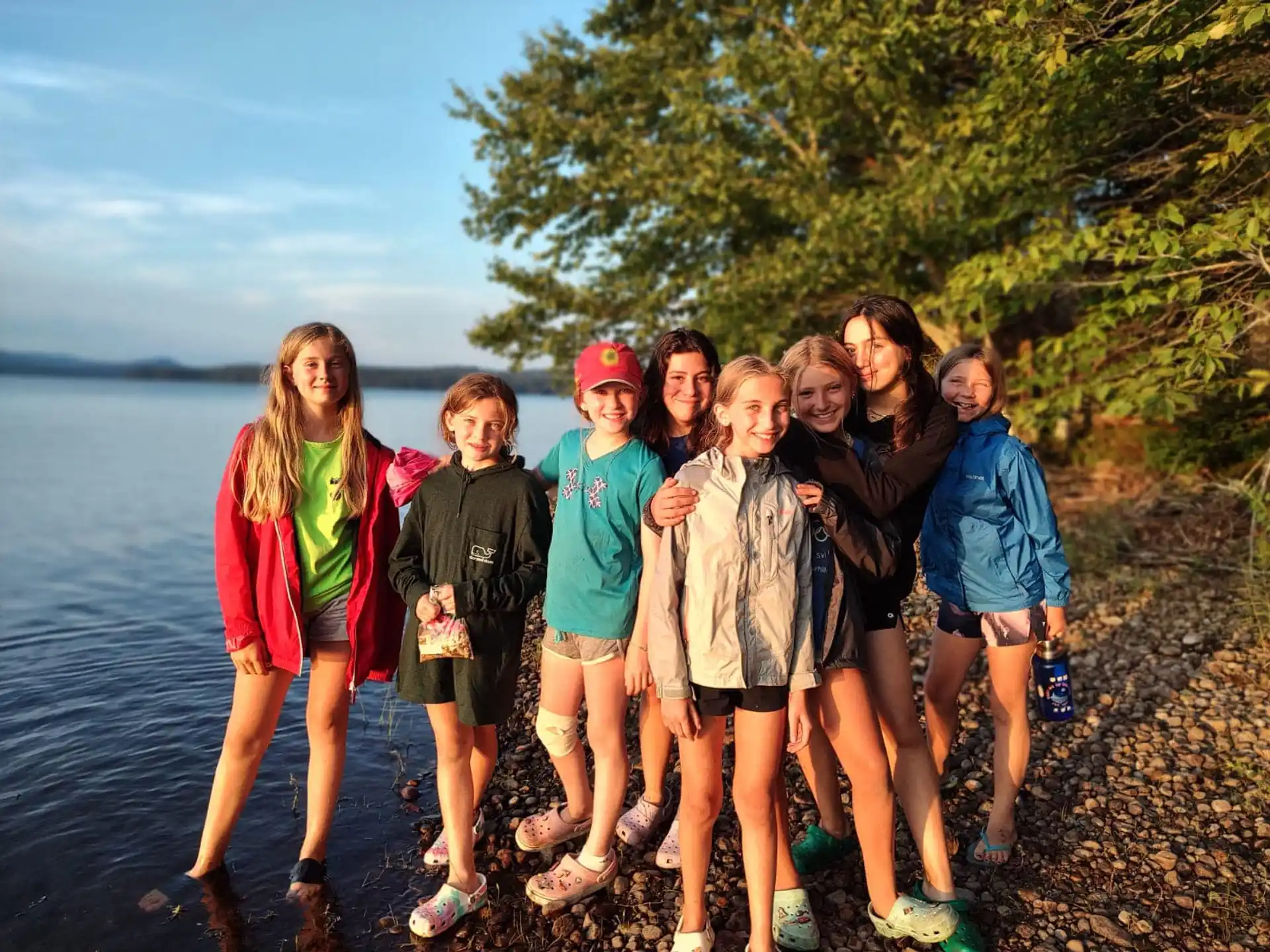 a group of people posing for a photo on a rocky beach
