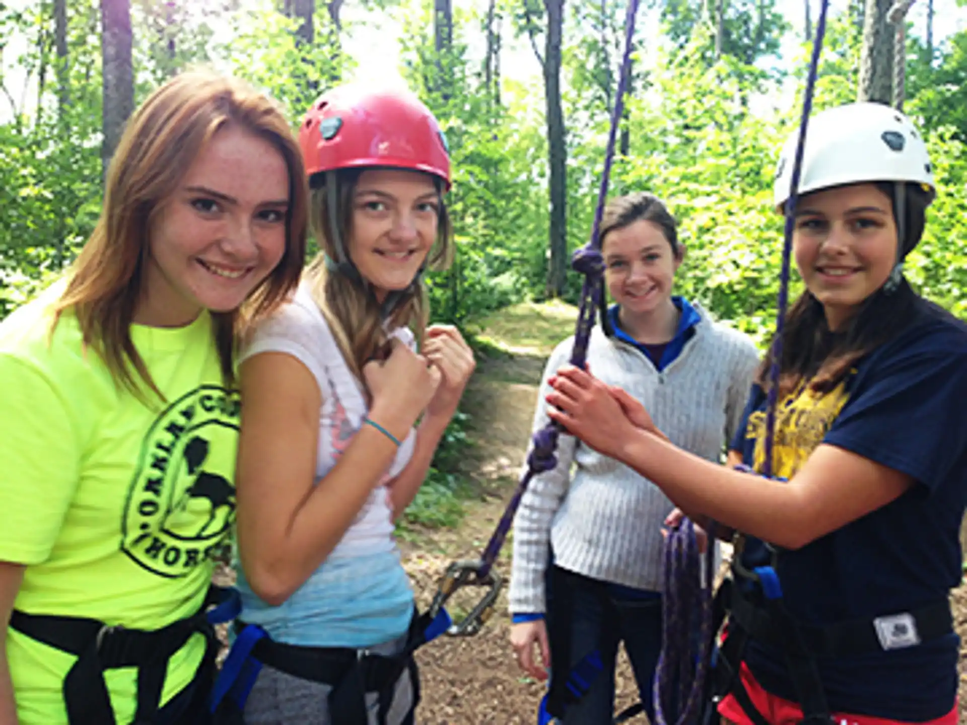 a group of girls wearing helmets and holding a bow and arrow