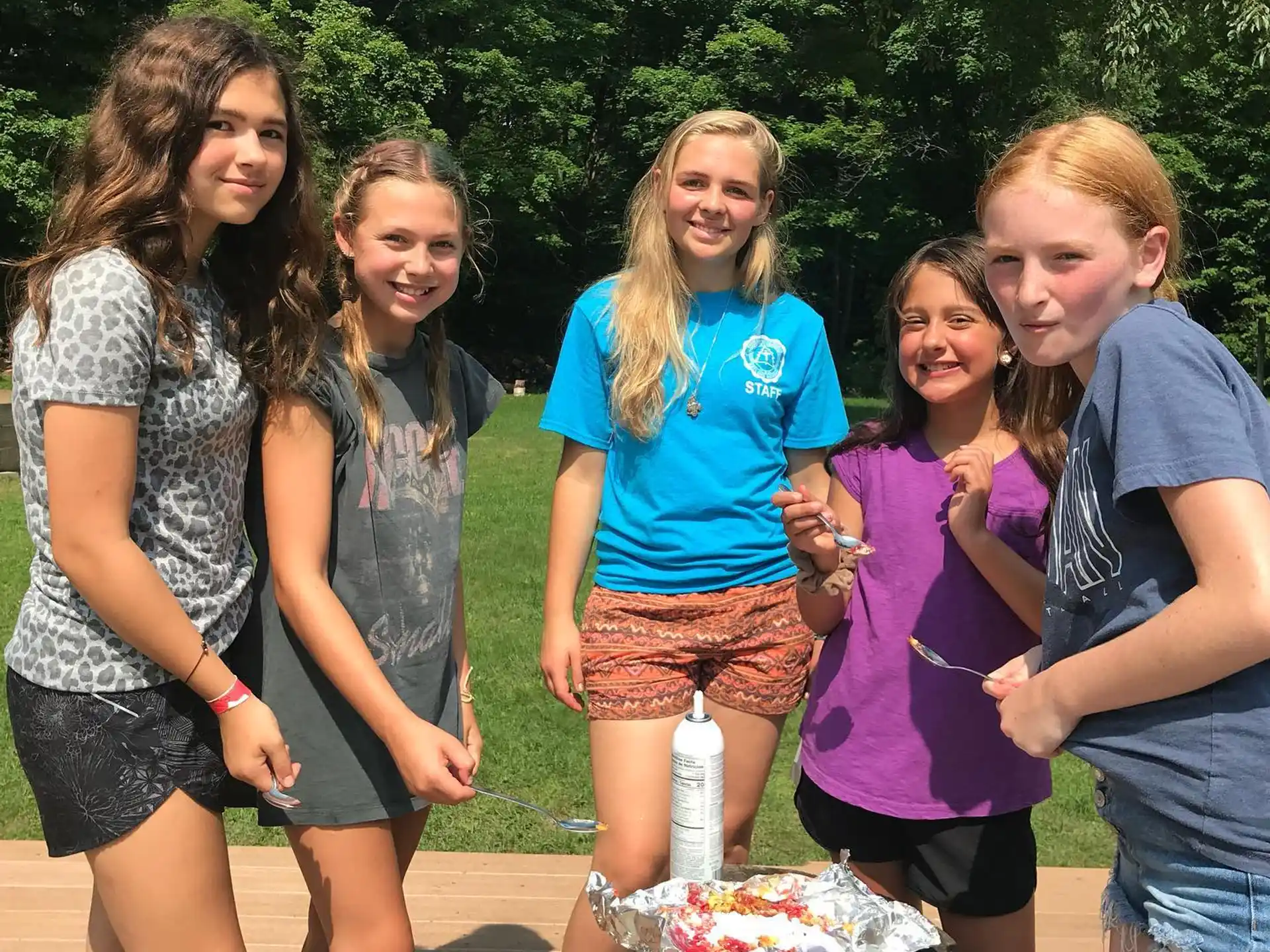 a group of people standing around a cake