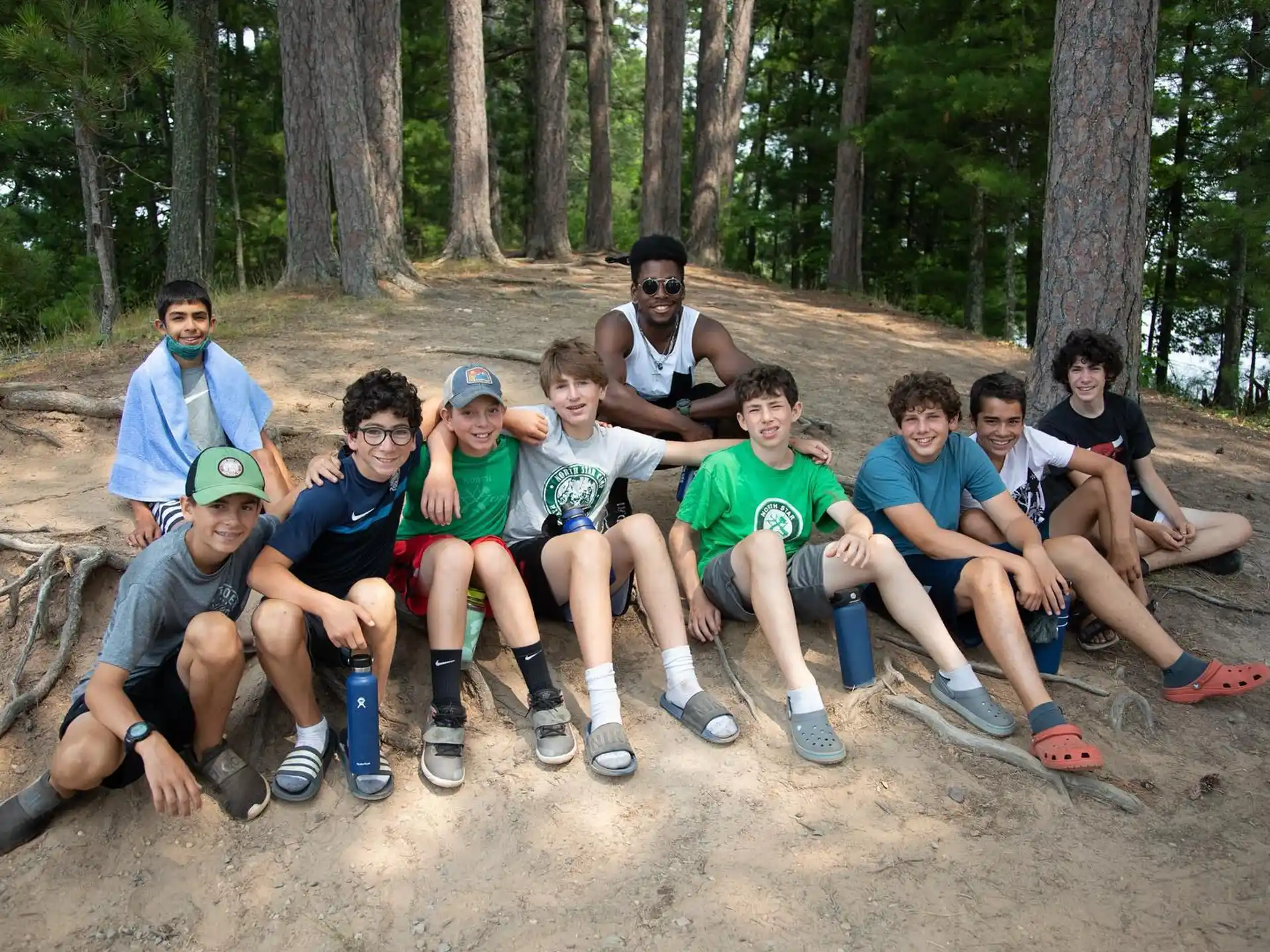 a group of people sitting on a log in the woods