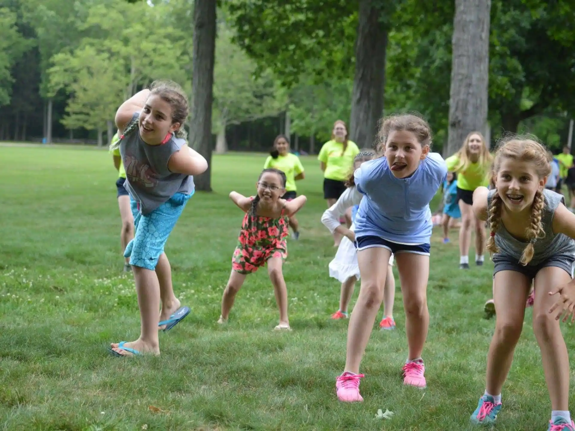 a group of people running on a grass field