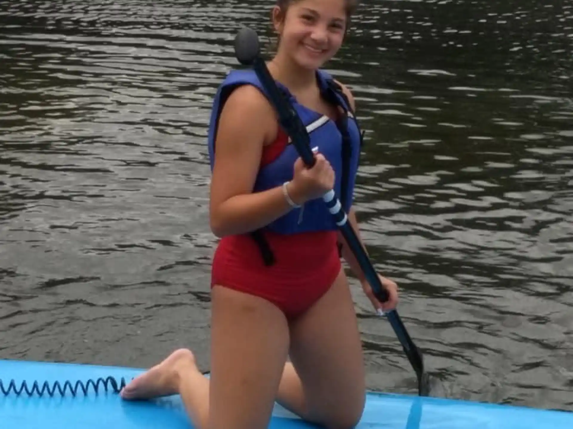 a person in a life jacket on a paddle board