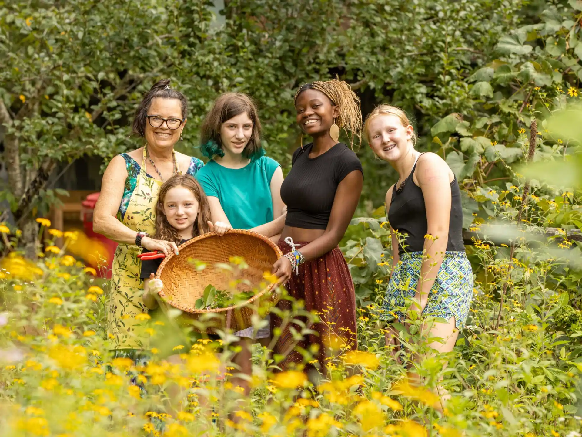 a group of women posing for a picture in a field of flowers