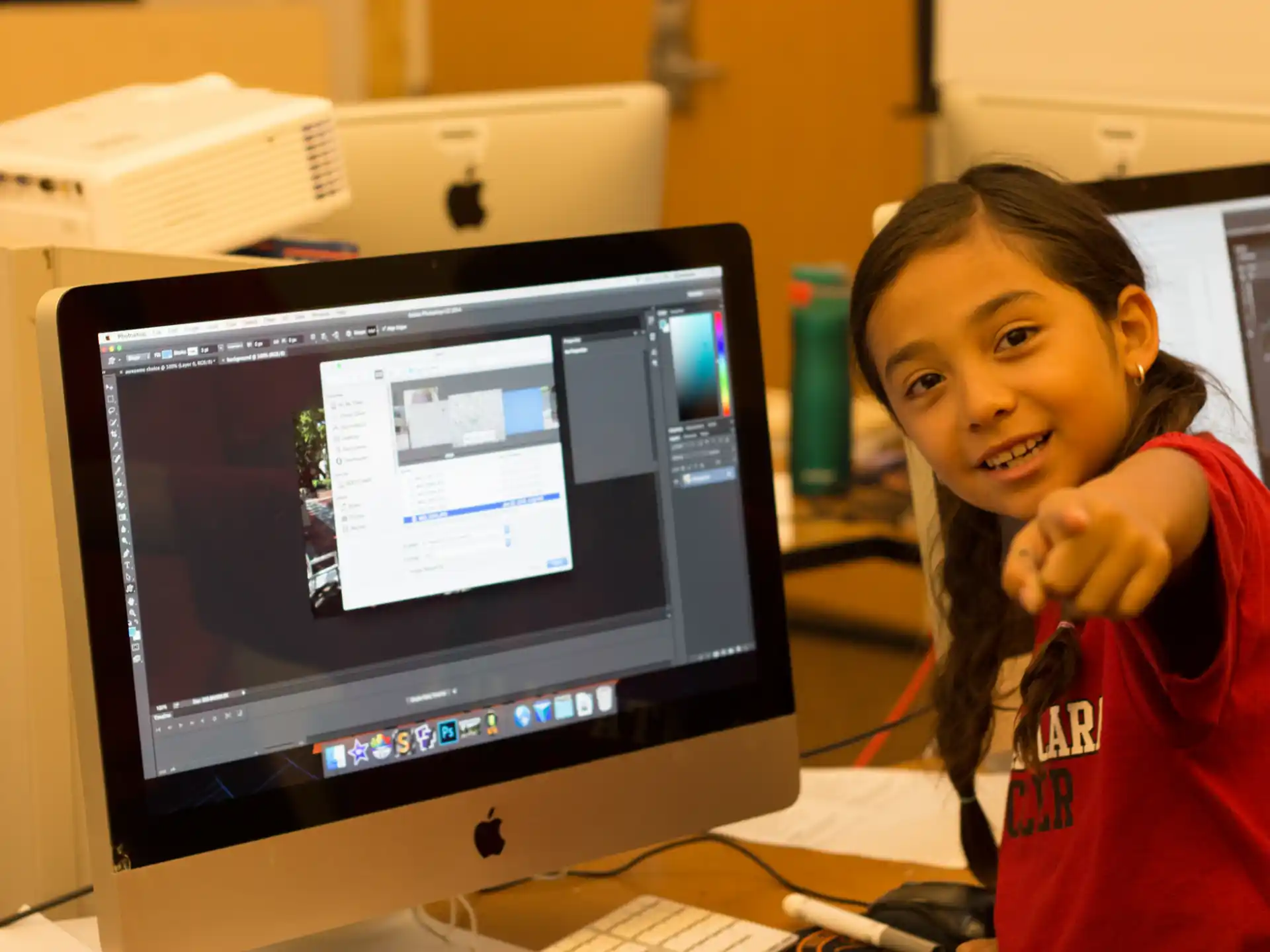 a girl smiling and looking at a computer screen