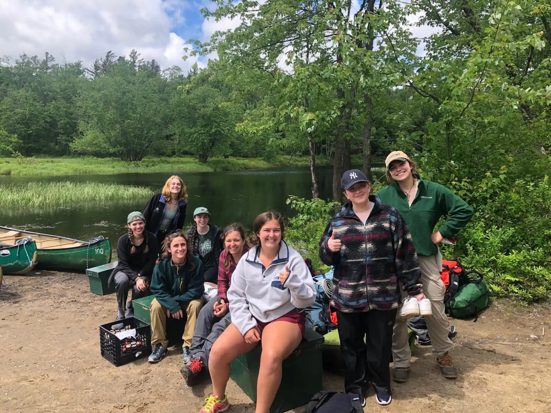 a group of people posing for a photo by a lake